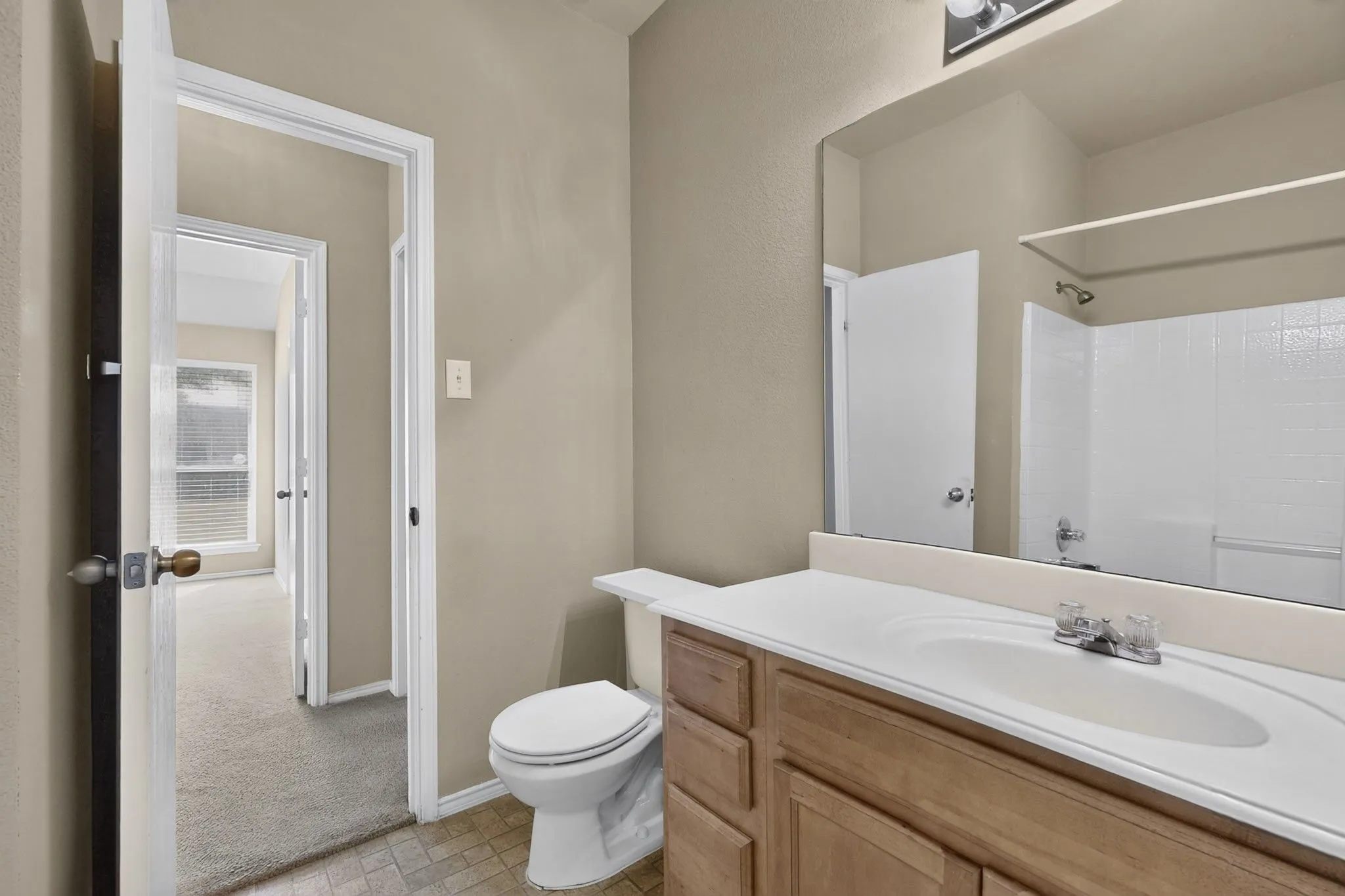 Wood-finish vanity with a white countertop and integrated sink