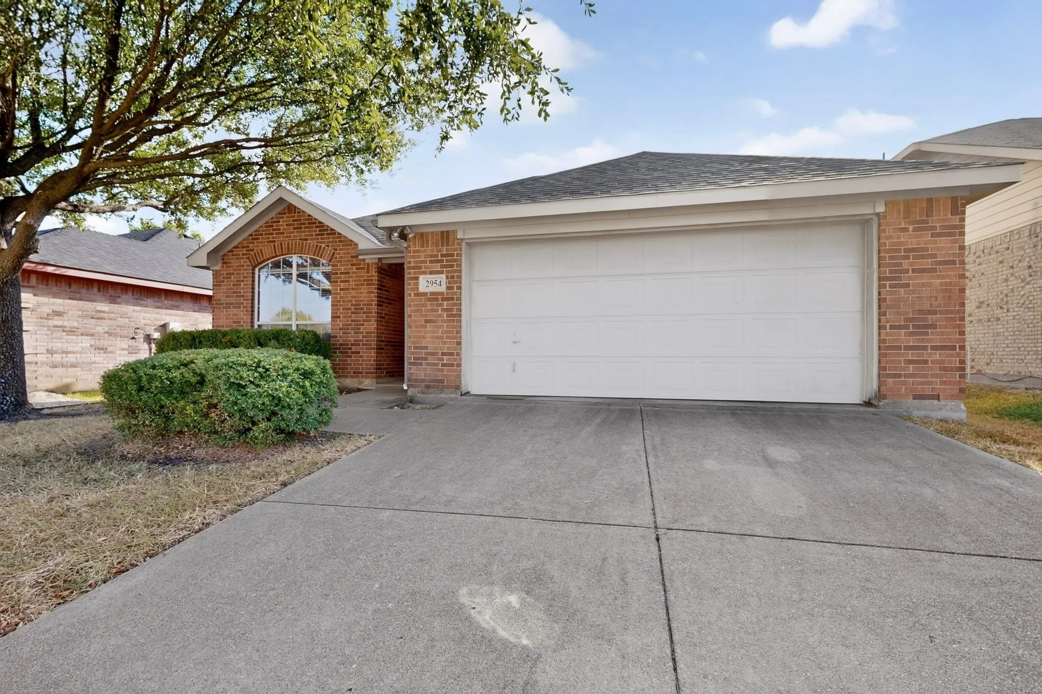 Brick exterior with a gabled entry, arched window, and attached garage