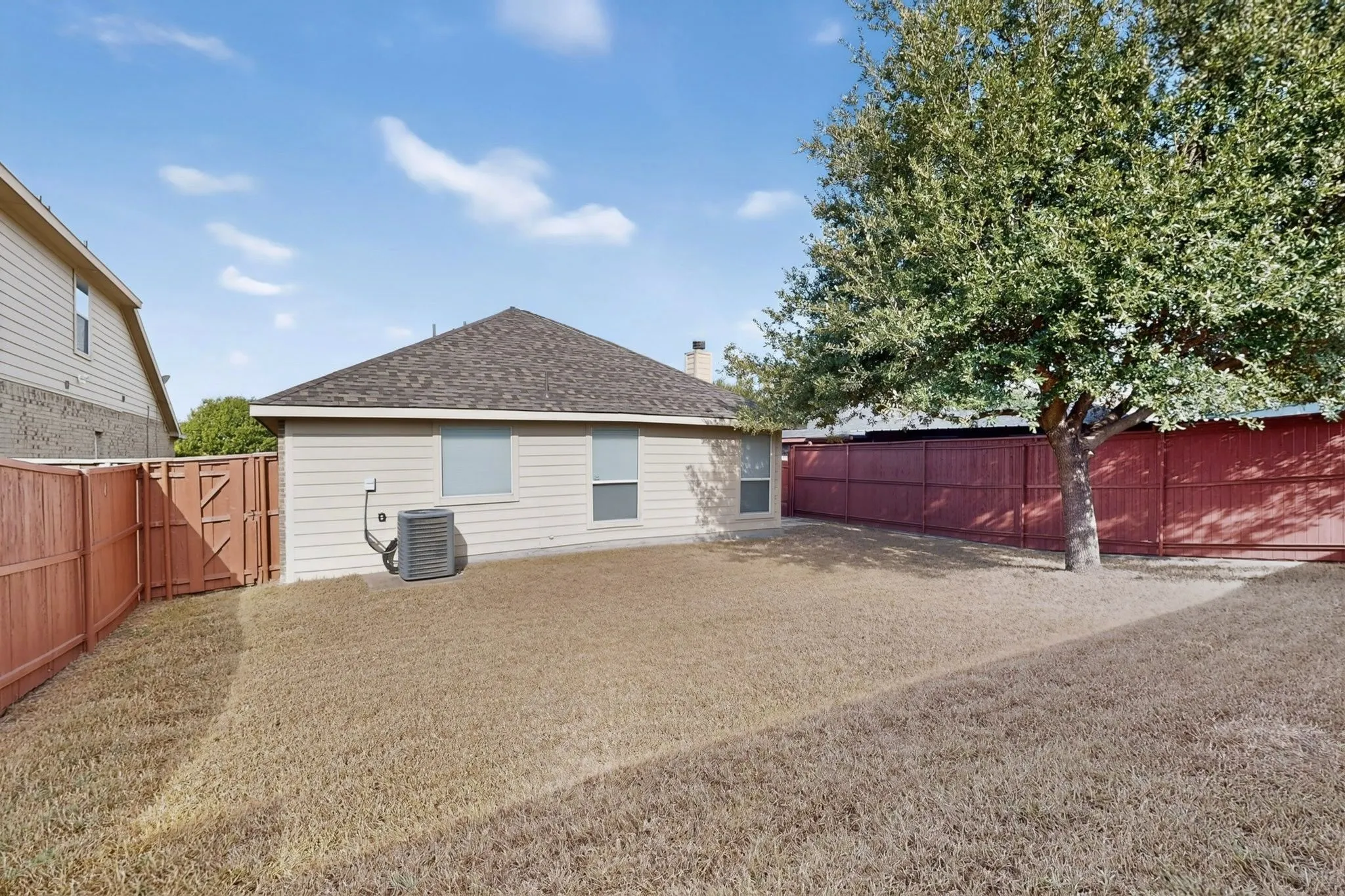 Fenced backyard with a mature tree