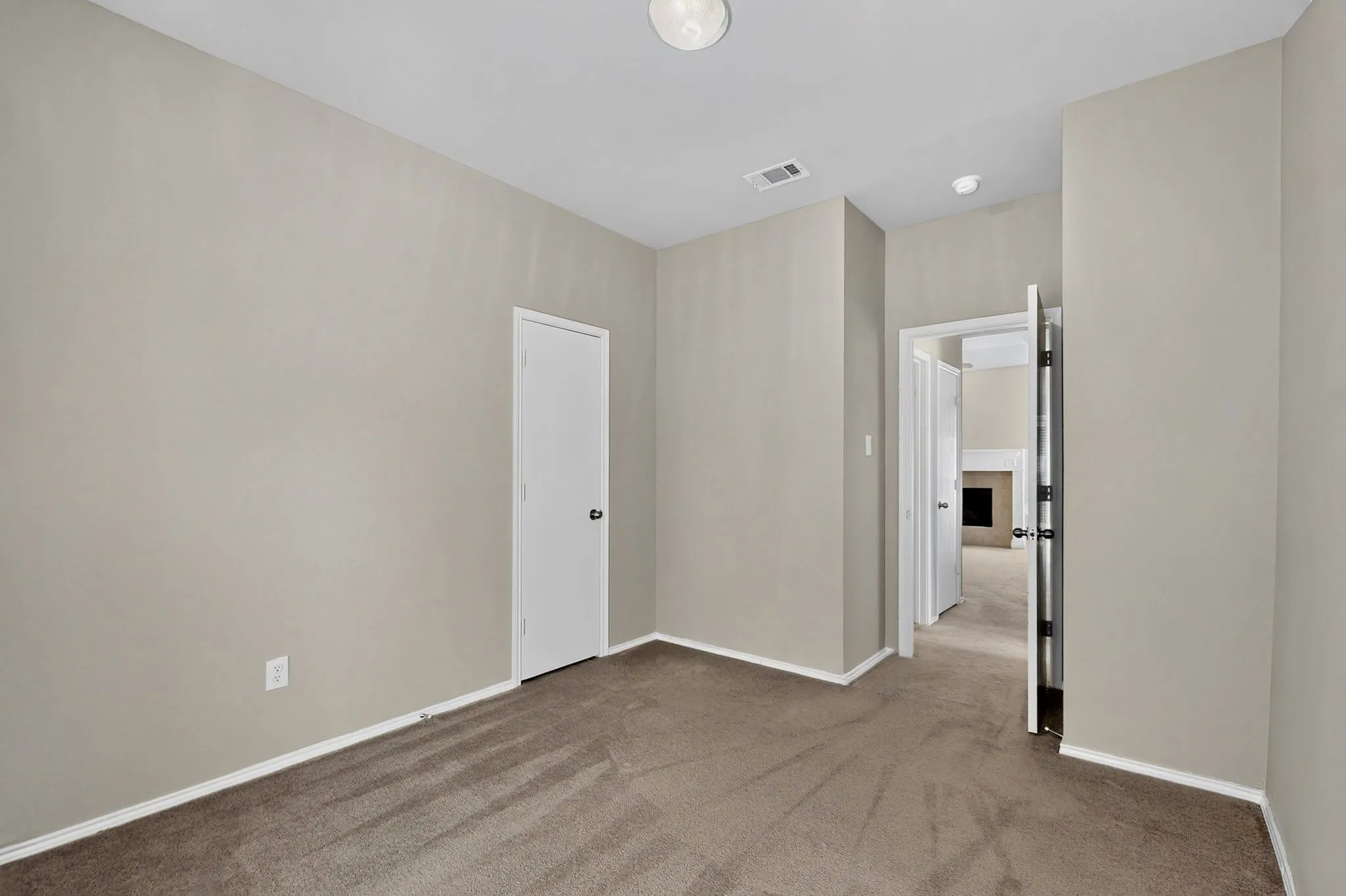 Carpeted flooring, neutral wall tones, white trim, and a flush mount ceiling light fixture