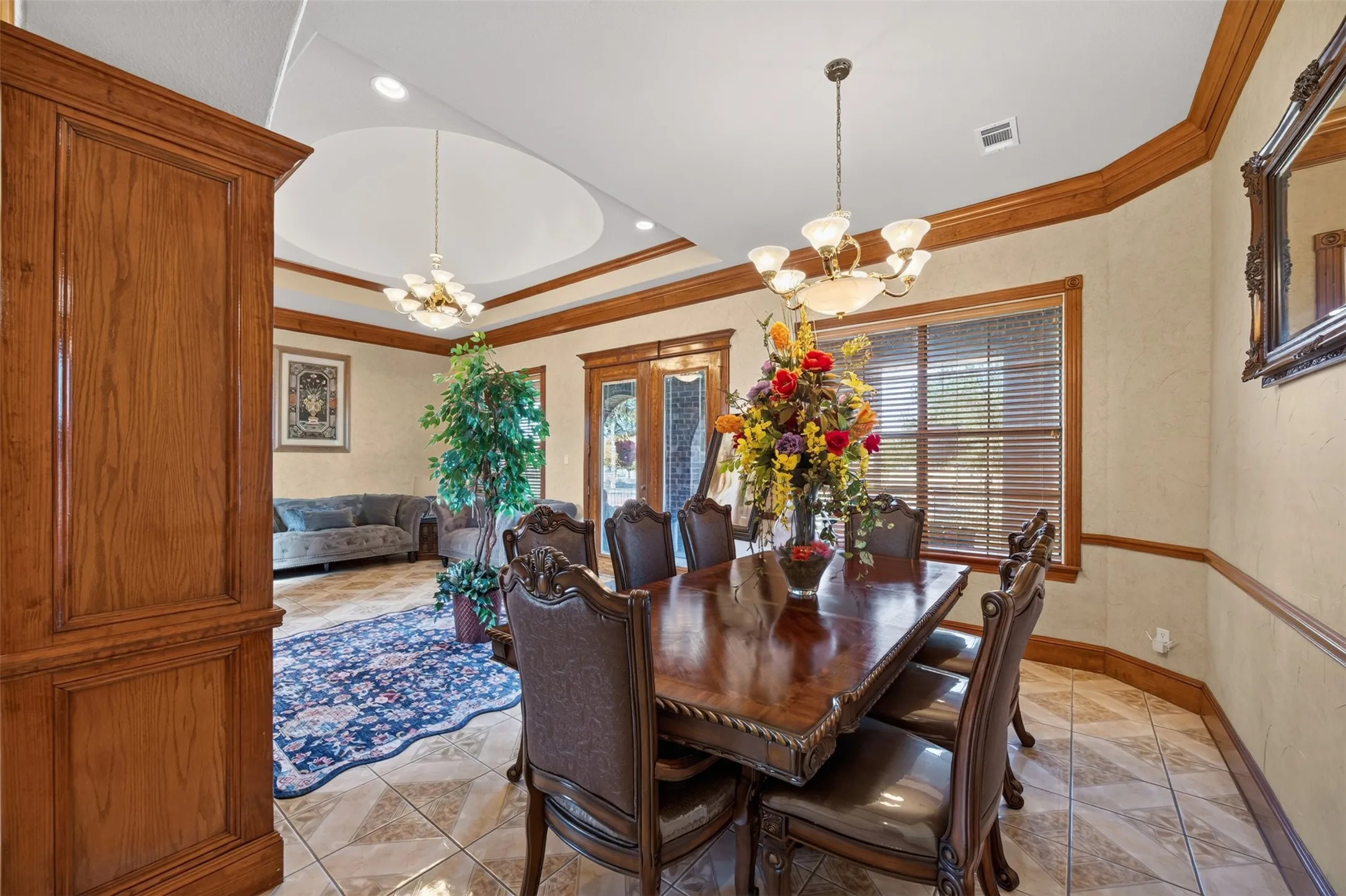 Formal dining with tile floors, crown moulding and wainscoting