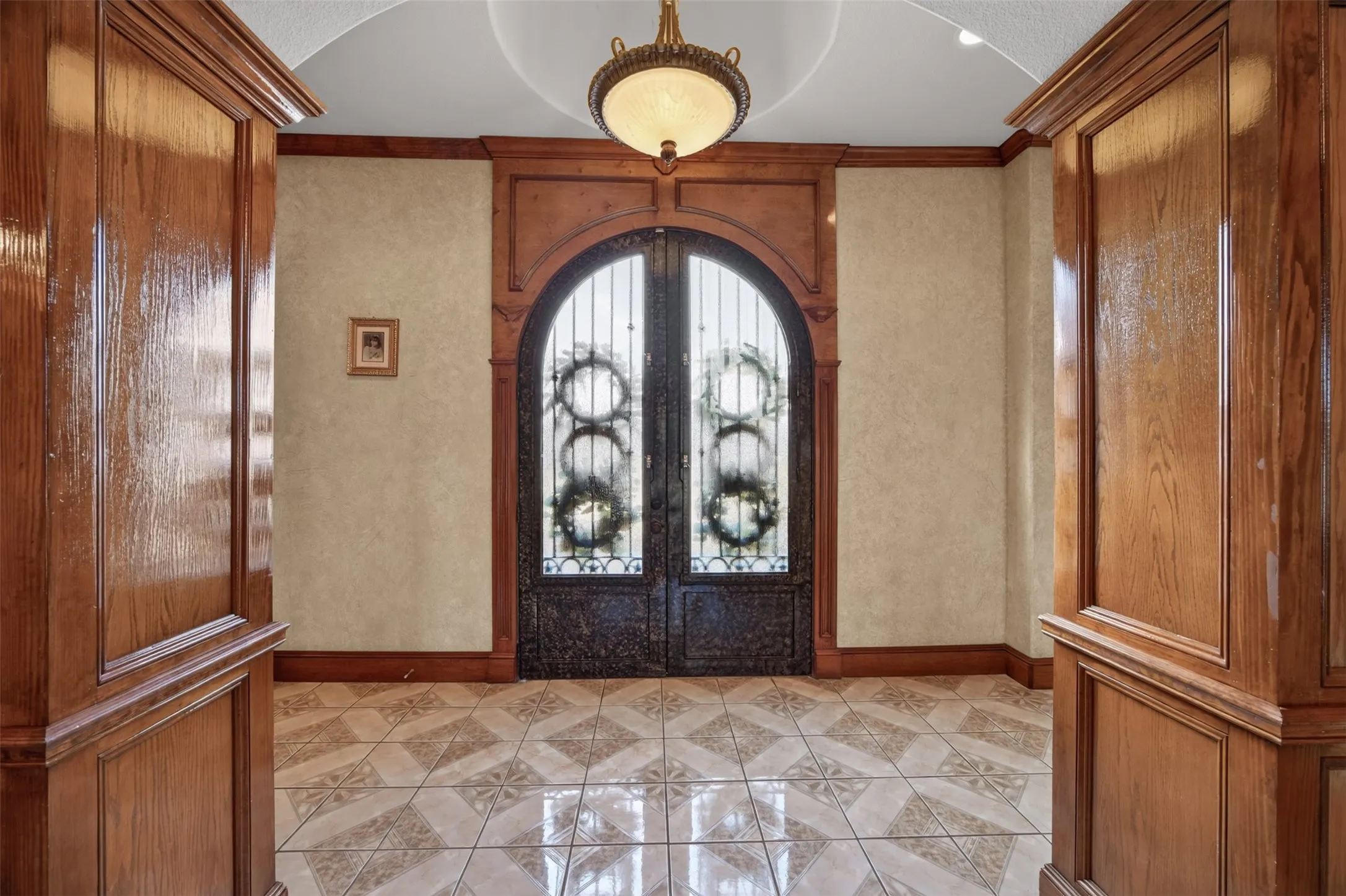 Stunning arched double iron and glass entry doors make a statement