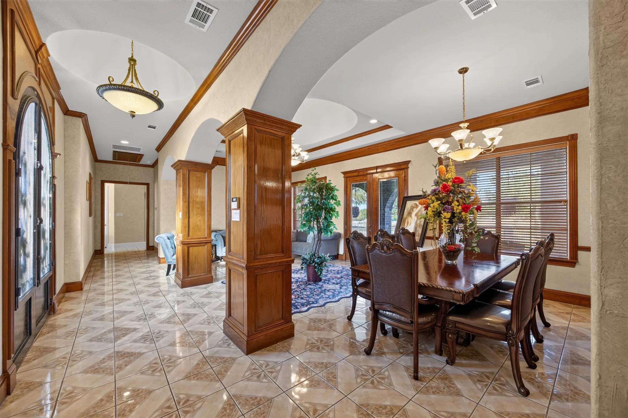 Formal dining with tile floors, crown moulding and wainscoting