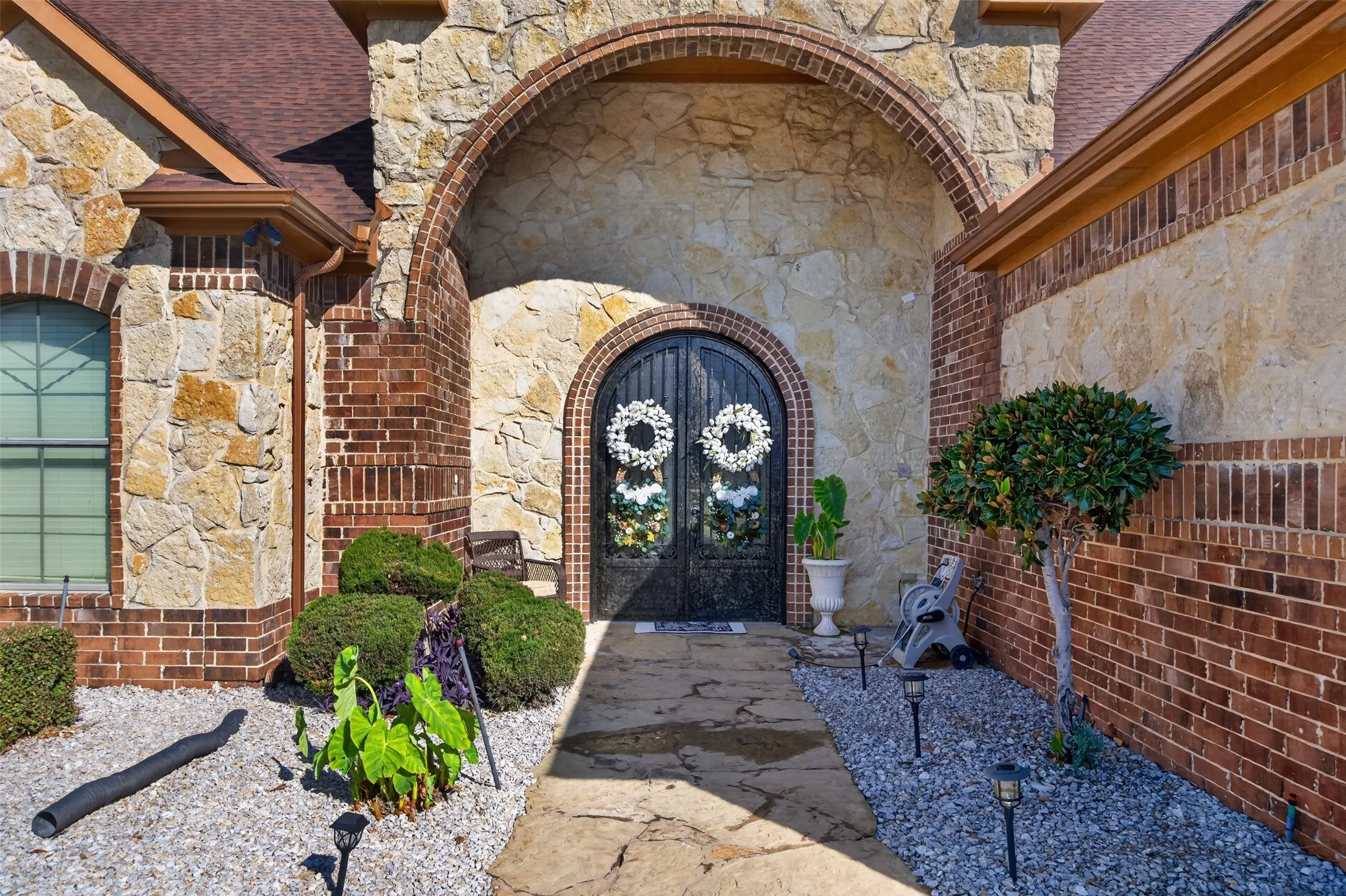 Stunning arched double iron and glass entry doors make a statement