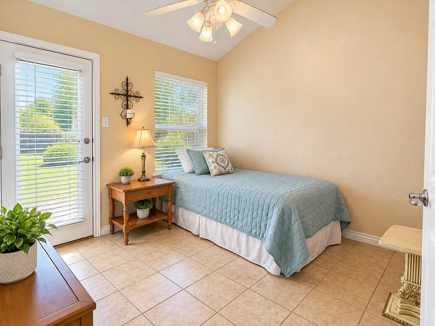 Vaulted ceiling, ceramic tile flooring, ceiling fan, and French-style door with integrated blinds