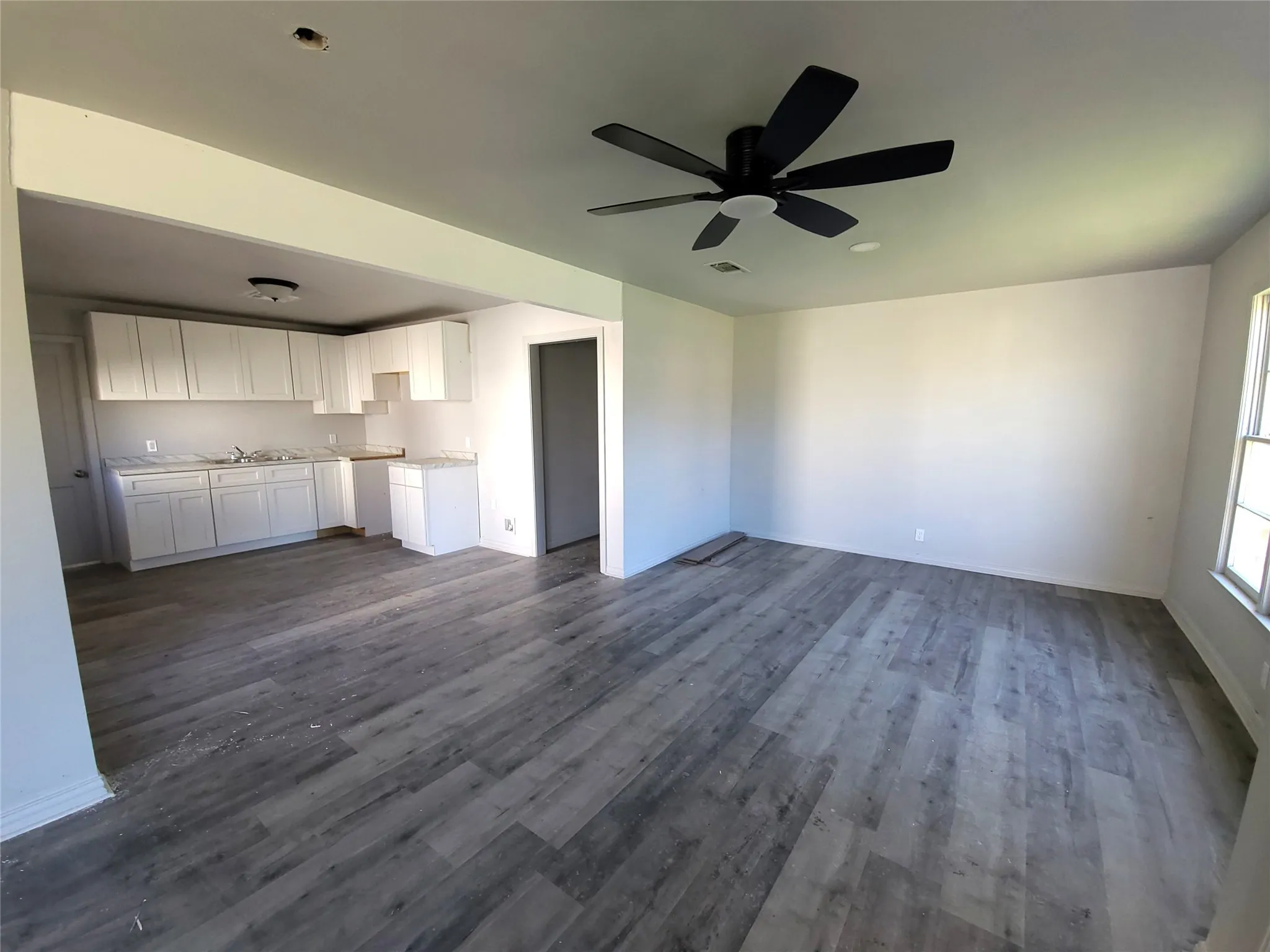 living room / Dining room Combo with ceiling fan and dark wood finished floors