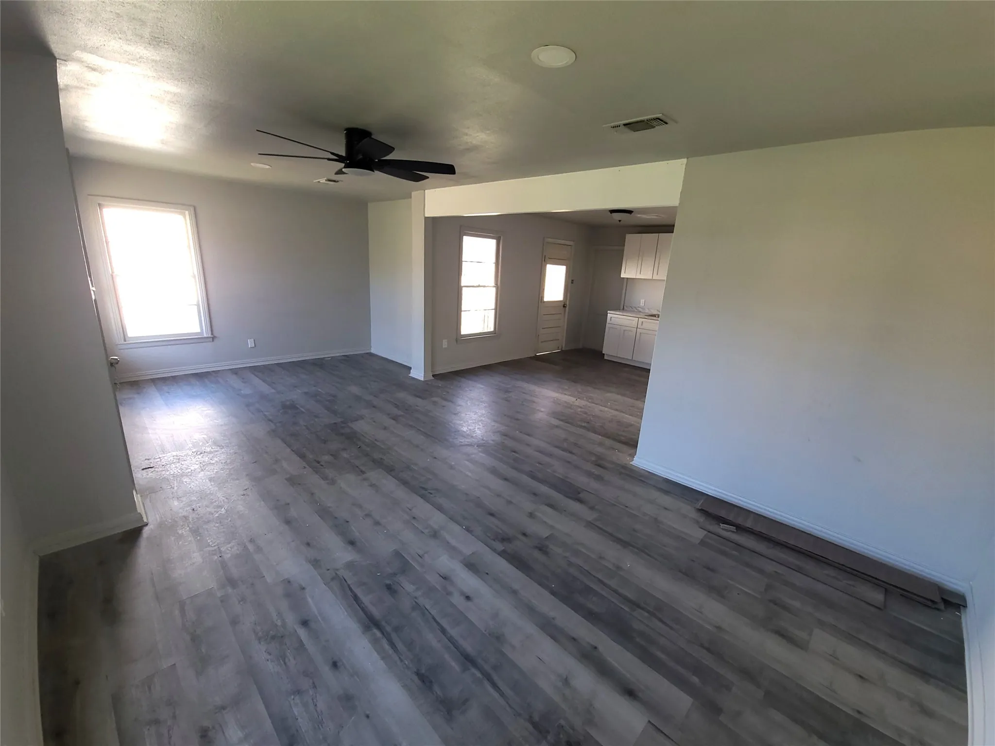 living room / Dining Room featuring plenty of natural light, dark wood-type flooring, and a ceiling fan