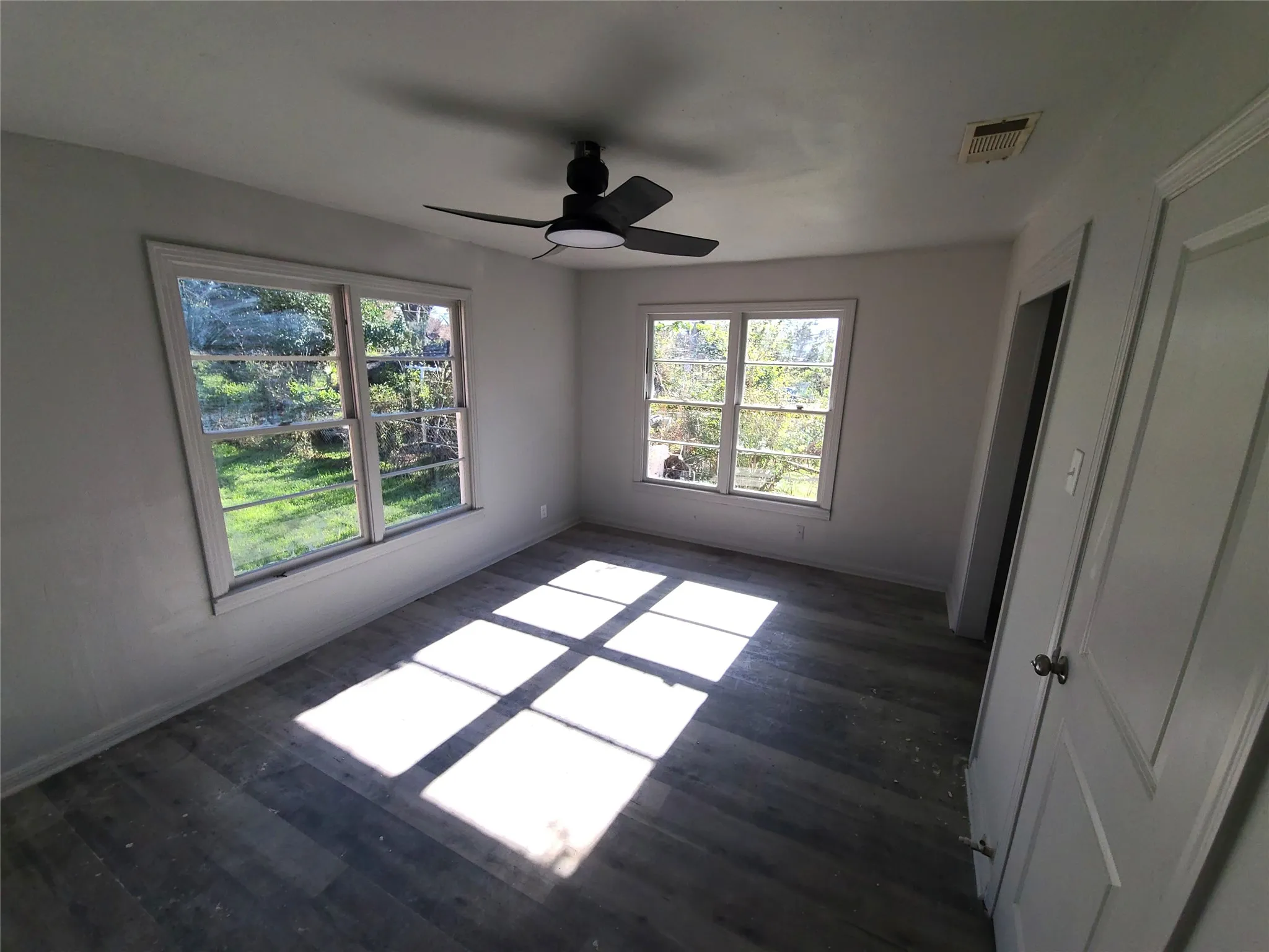 bedroom #4 with multiple windows, a ceiling fan, and dark wood finished floors