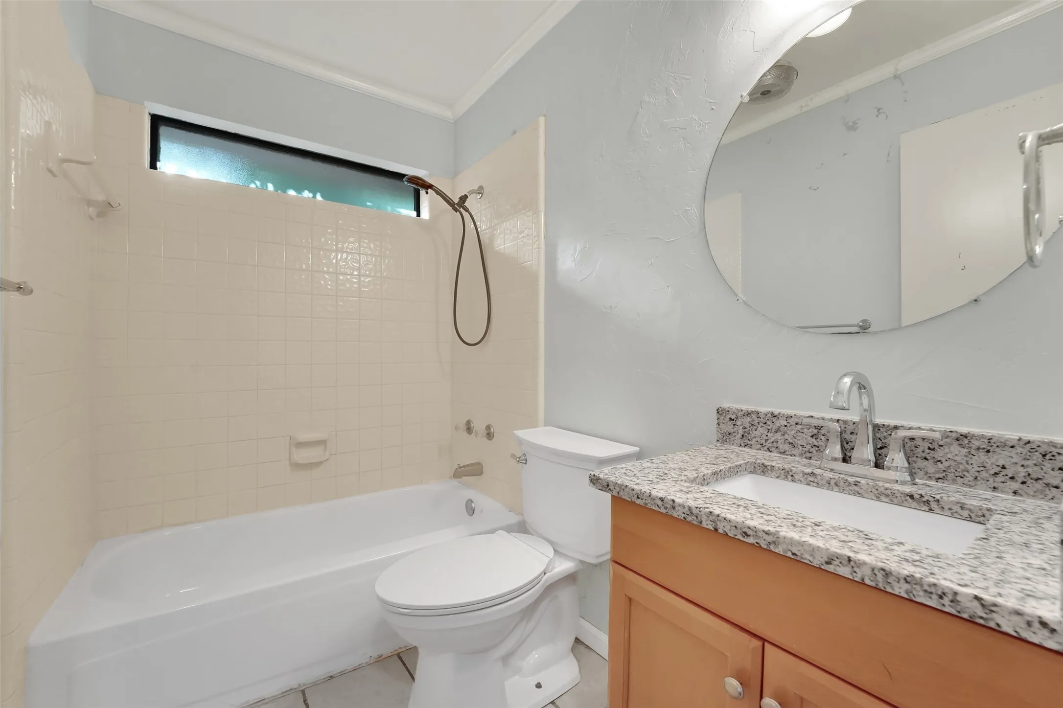 Bathtub with ceramic tile surround and transom window