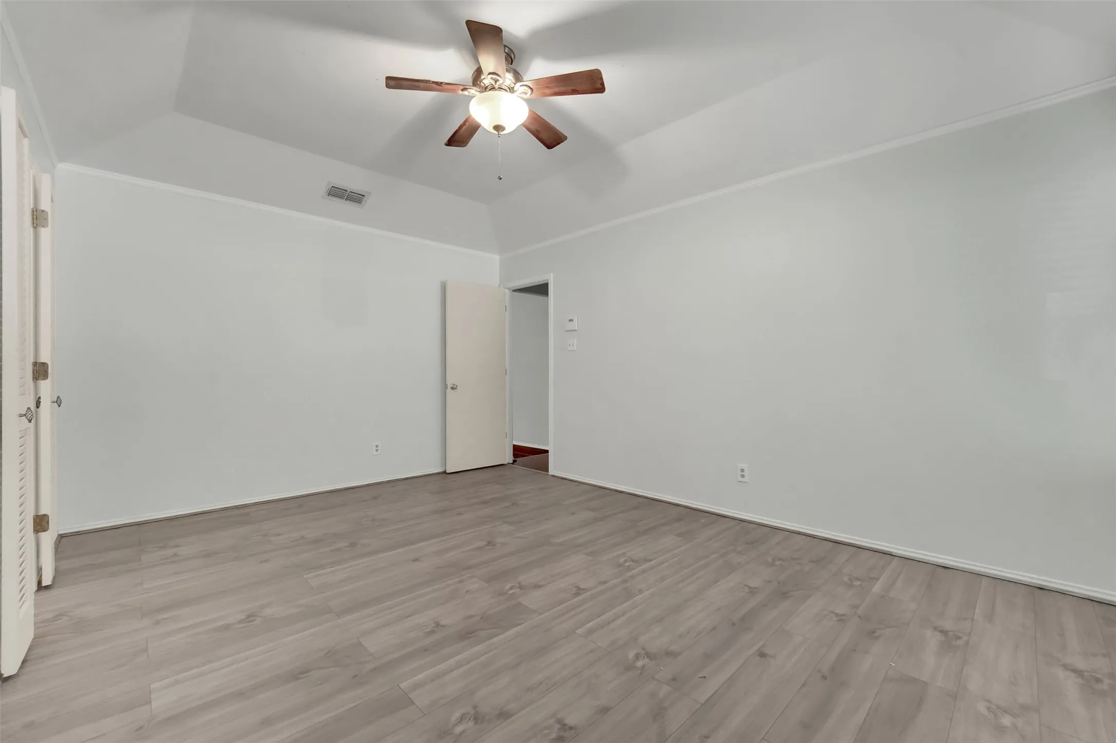Vaulted ceiling, wood-finish flooring, ceiling fan with integrated lighting