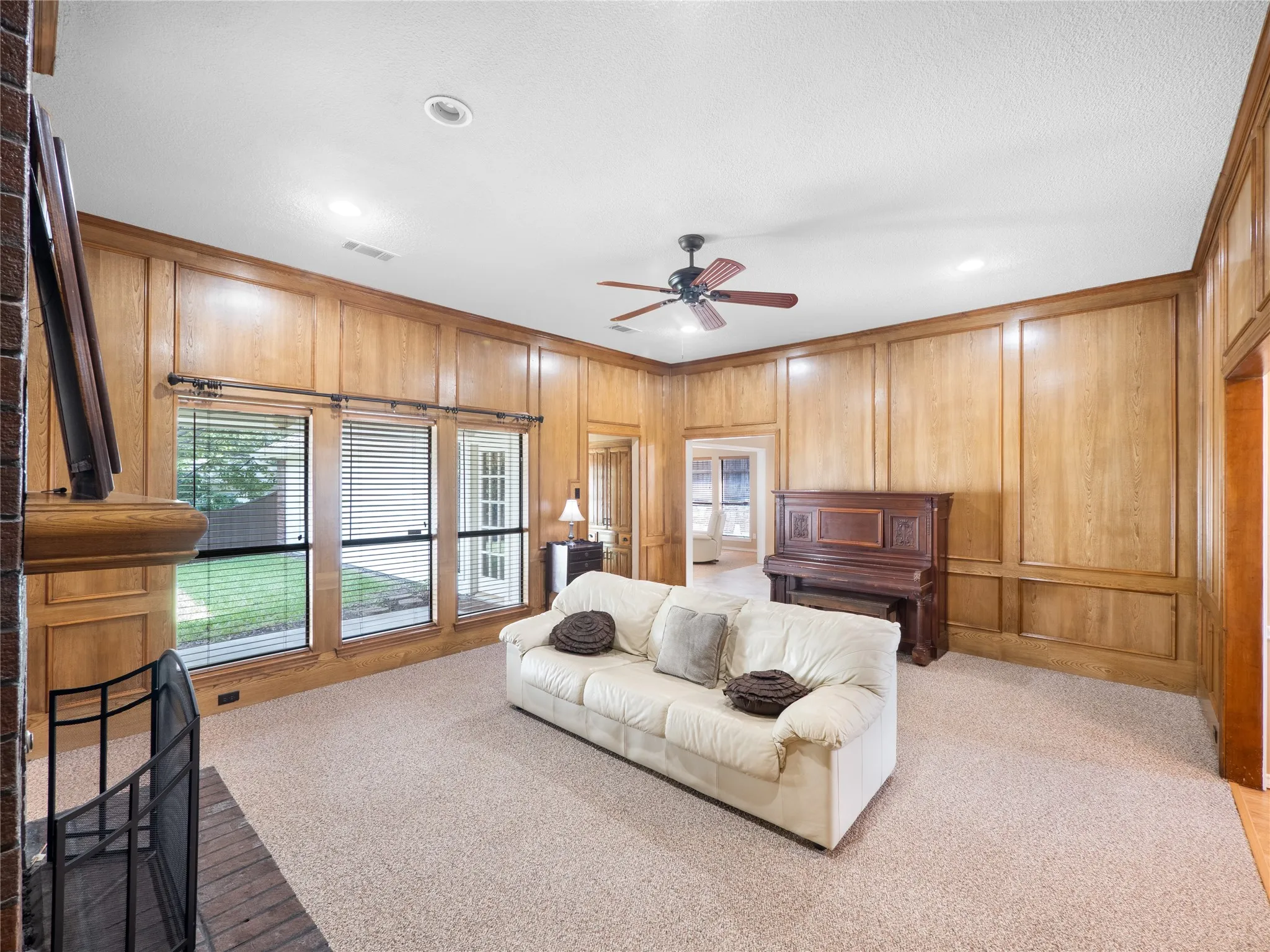Walk-in shower with tile surround, corner soaking tub, dual-sink vanity with wood-finish cabinetry, and dark countertop surfaces