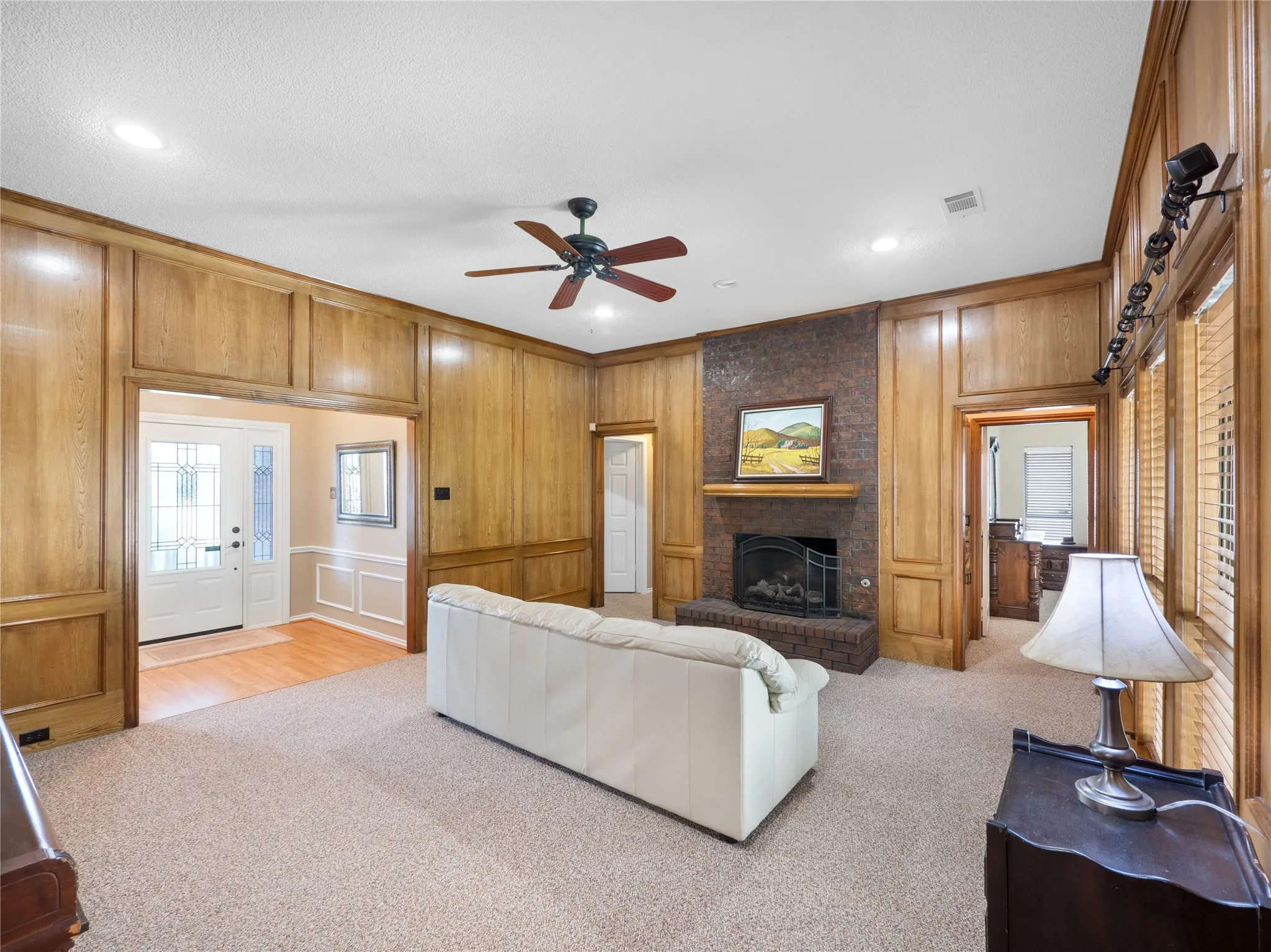 Tray ceiling with a ceiling fan, carpet flooring, and multiple windows