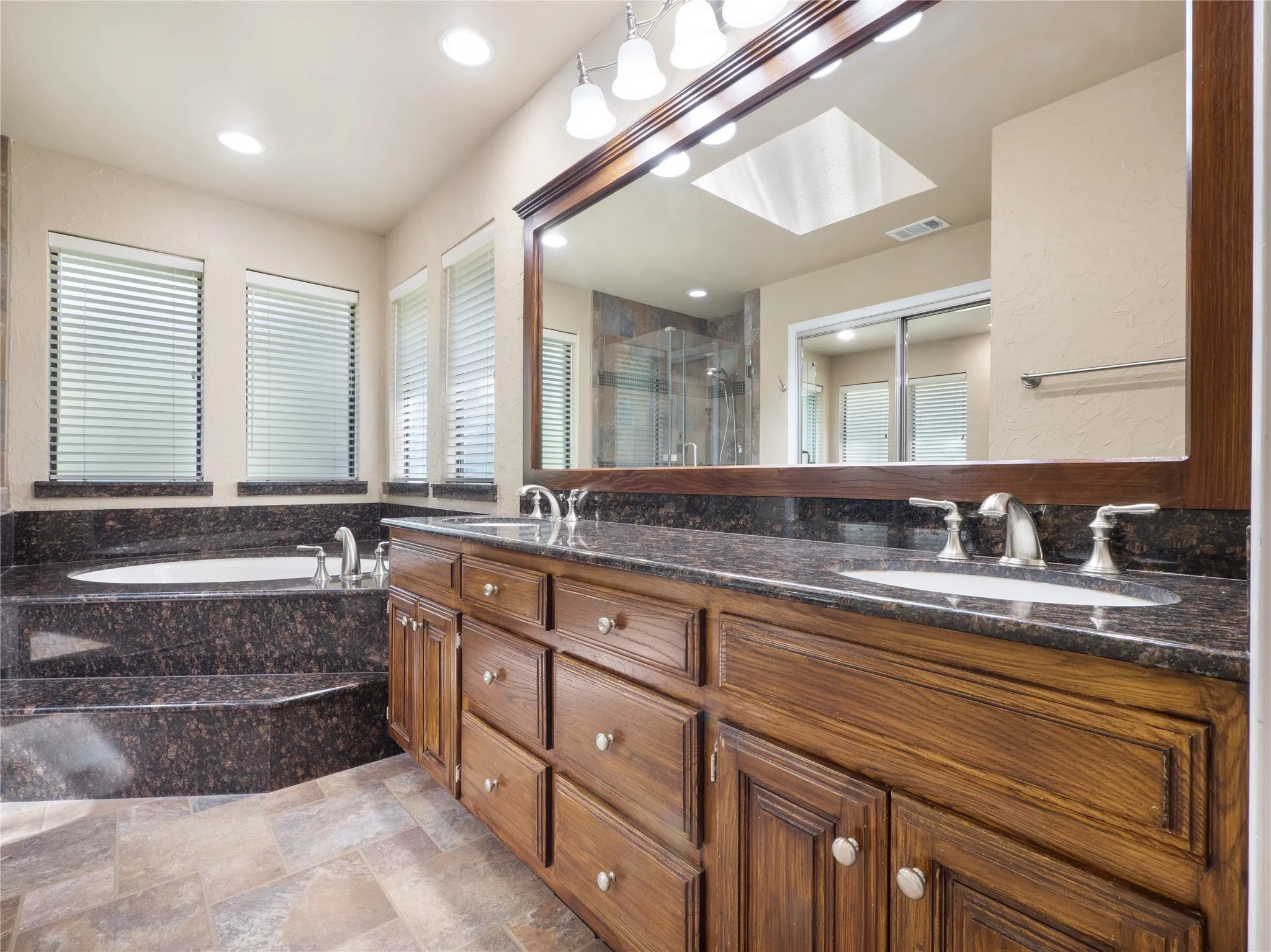 Primary bathroom with dual sinks, separate shower, and walk-in closet