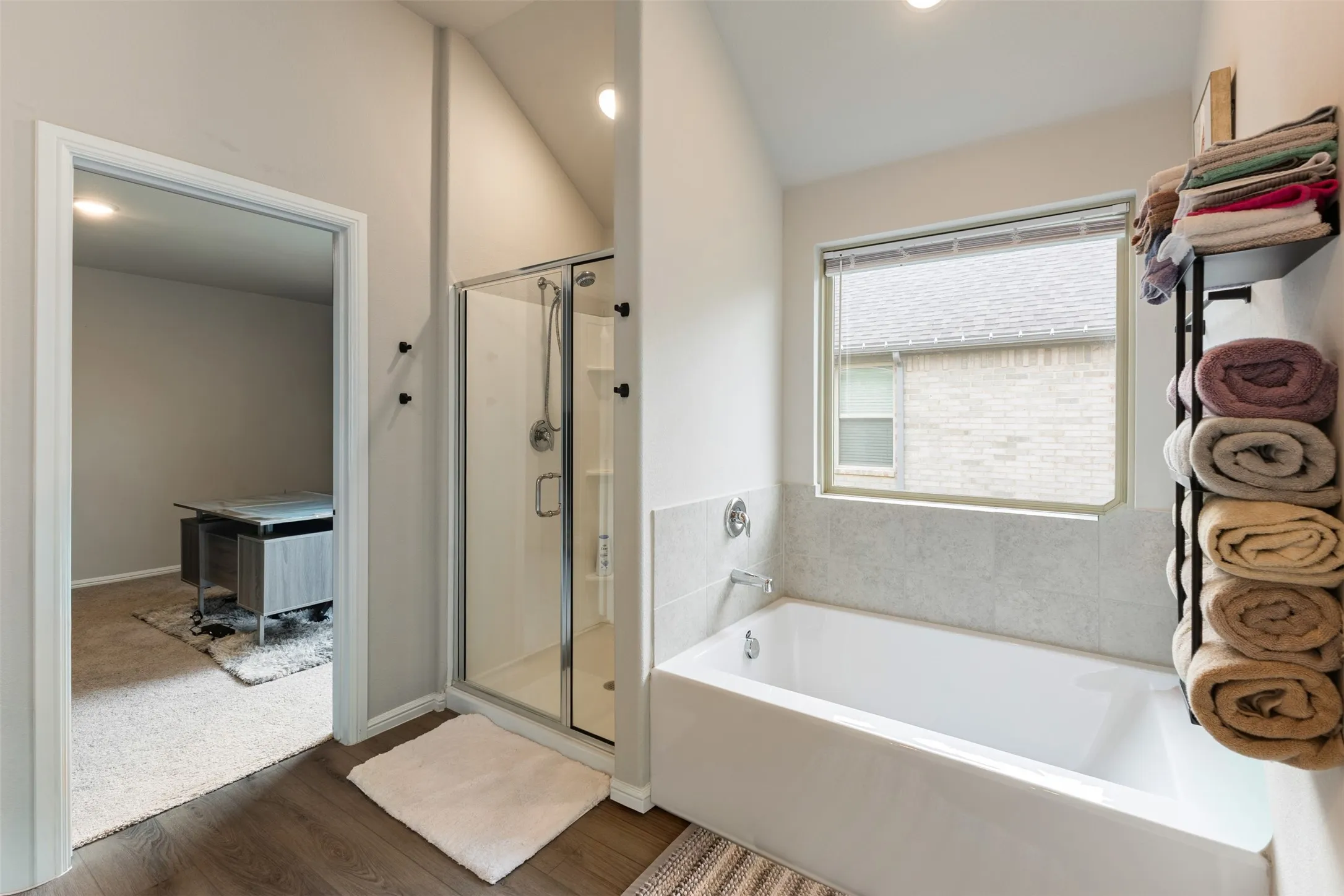 Full bathroom with a bath, a shower stall, dark wood finished floors, vaulted ceiling, and recessed lighting