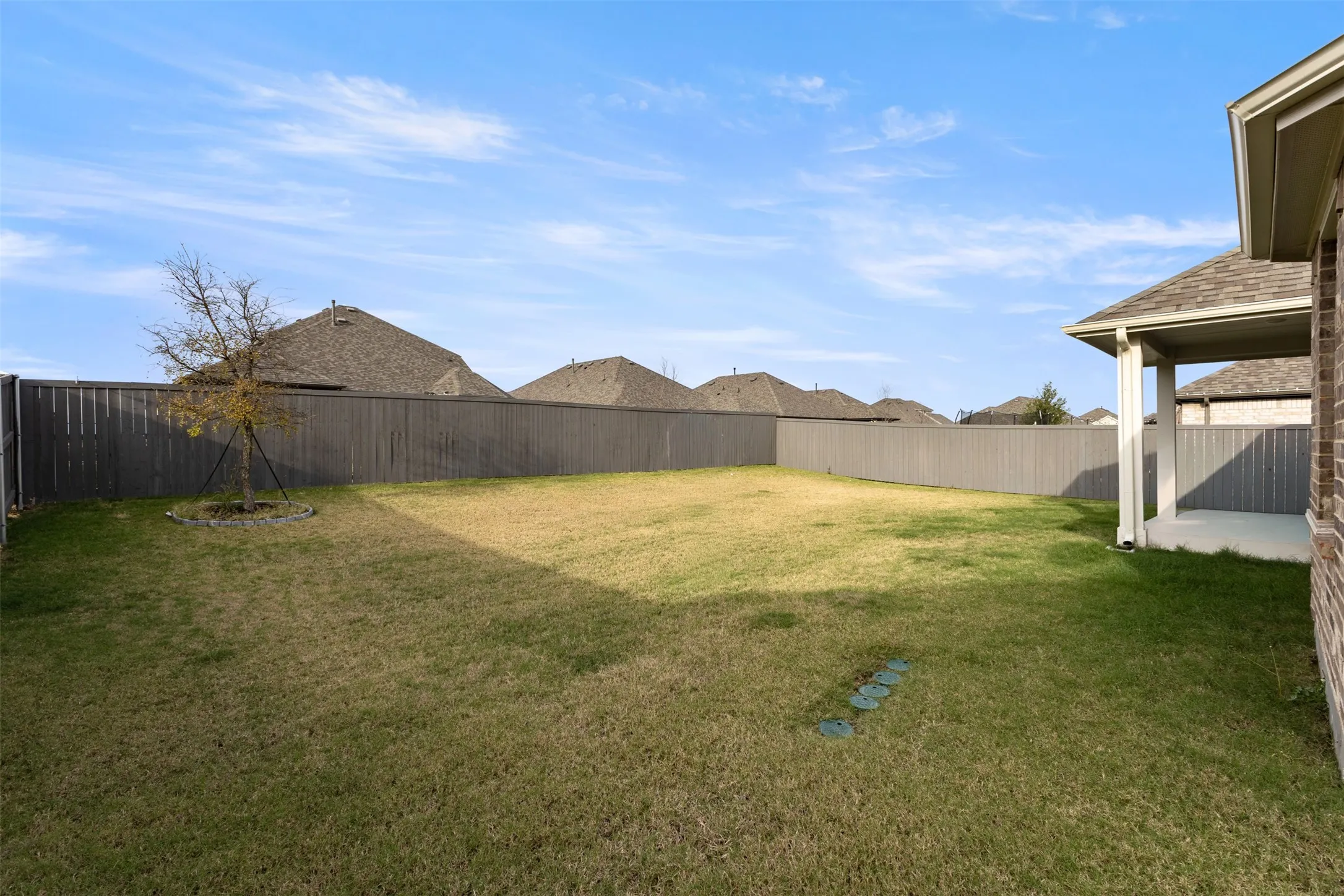 Fenced backyard with a patio area and a residential view