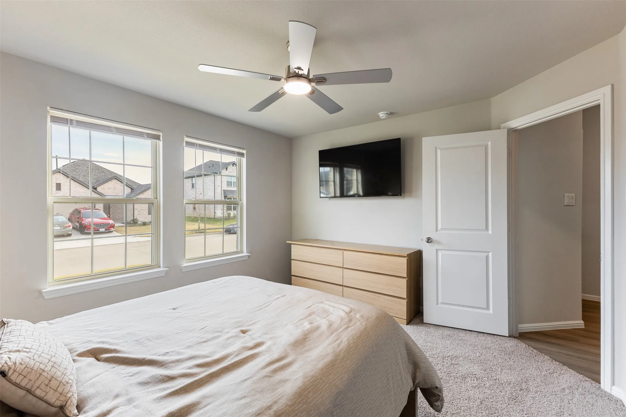 Carpeted bedroom with ceiling fan and baseboards