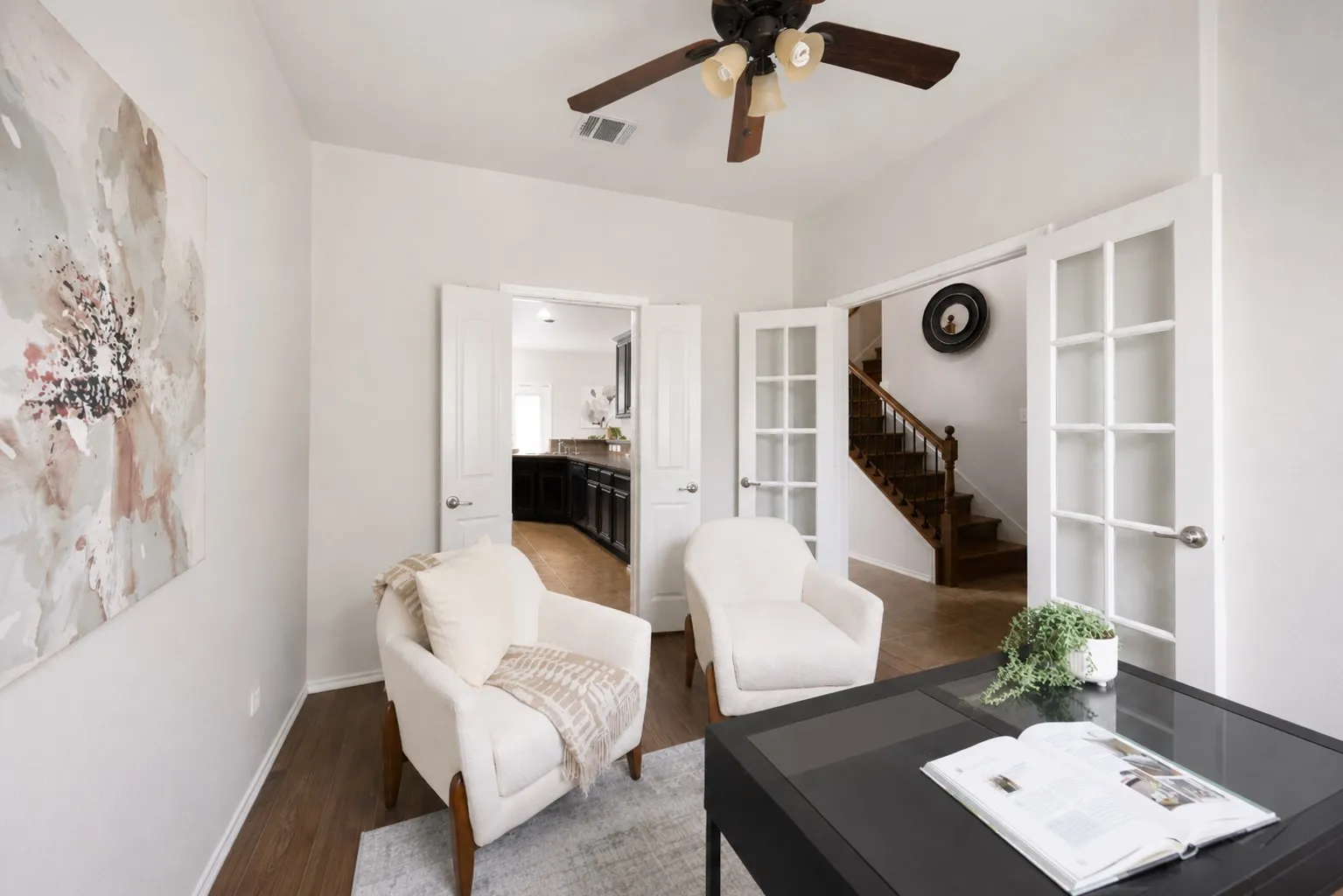 Vaulted ceiling with a ceiling fan, wood-finish flooring, and white interior doors with glass panels