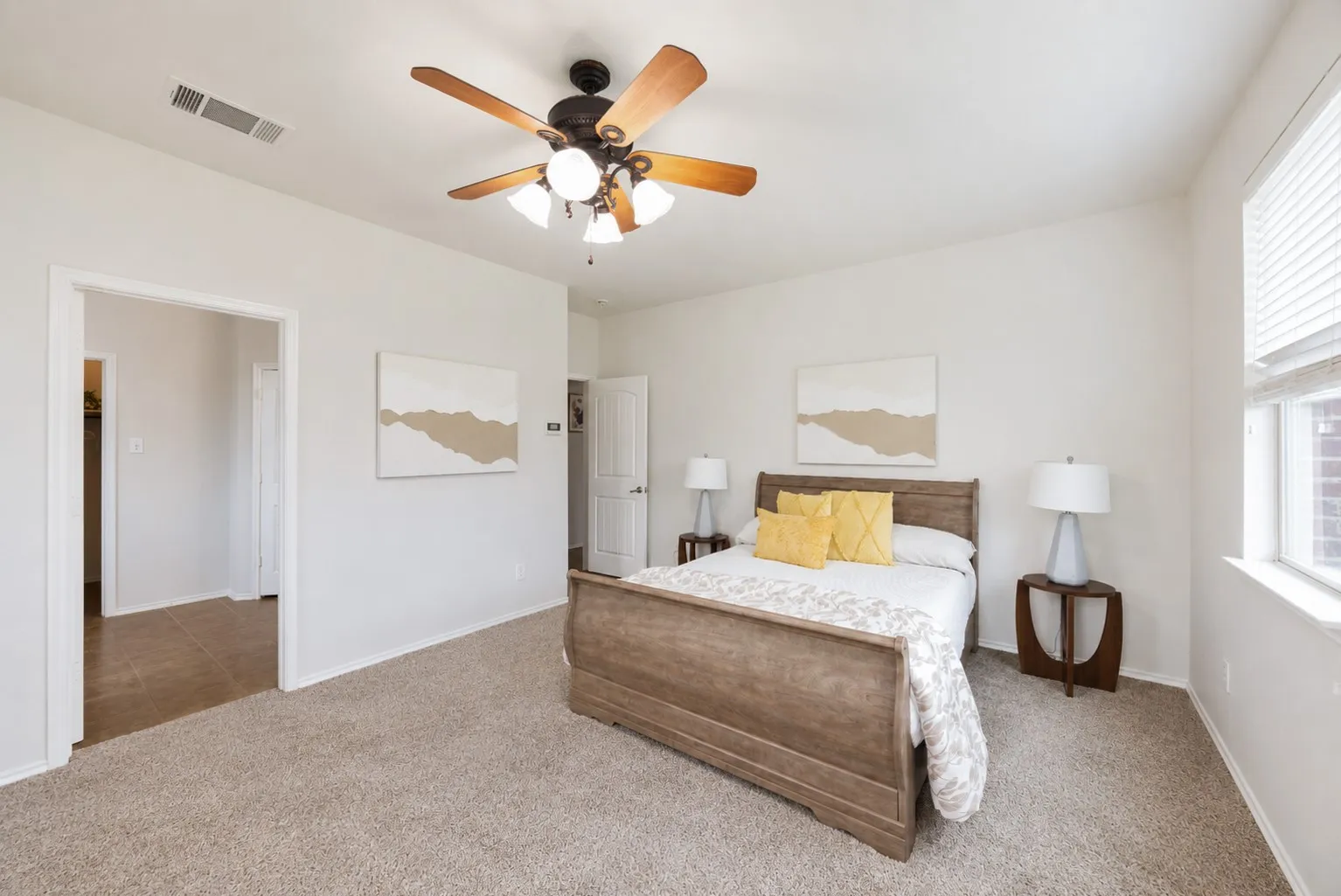 Plush carpet flooring, ceiling fan with integrated lighting, window with blinds, and white interior doors