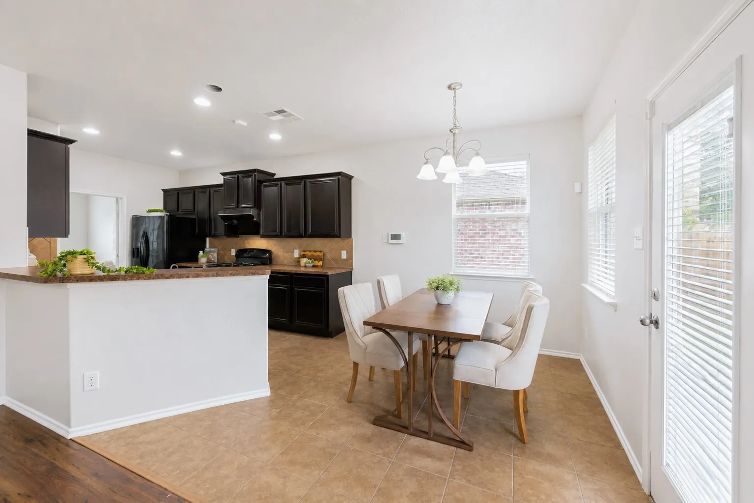 Kitchen with dark wood-finish cabinetry, recessed lighting, and a breakfast bar