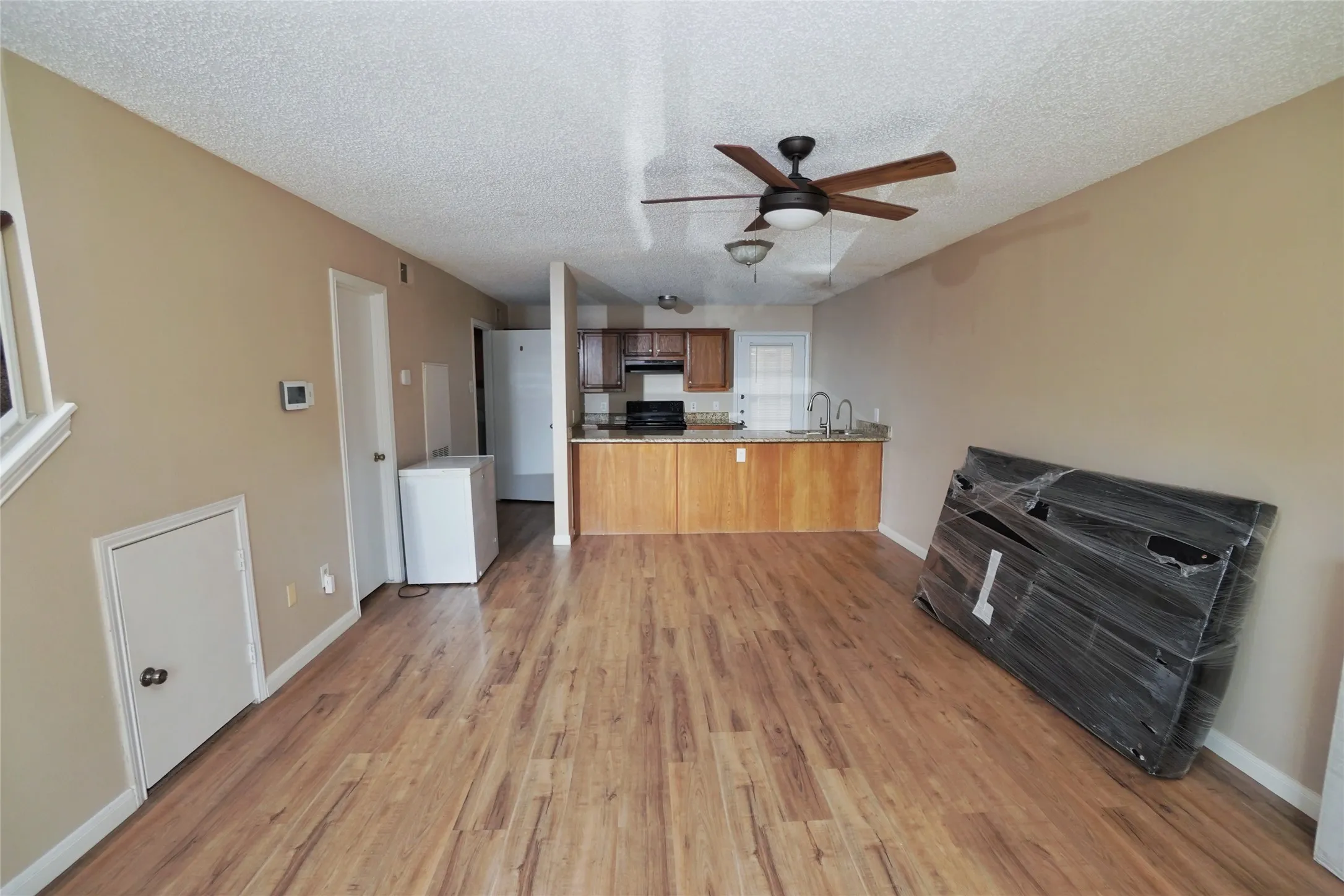 Wood-finish flooring throughout, with a ceiling fan and recessed lighting