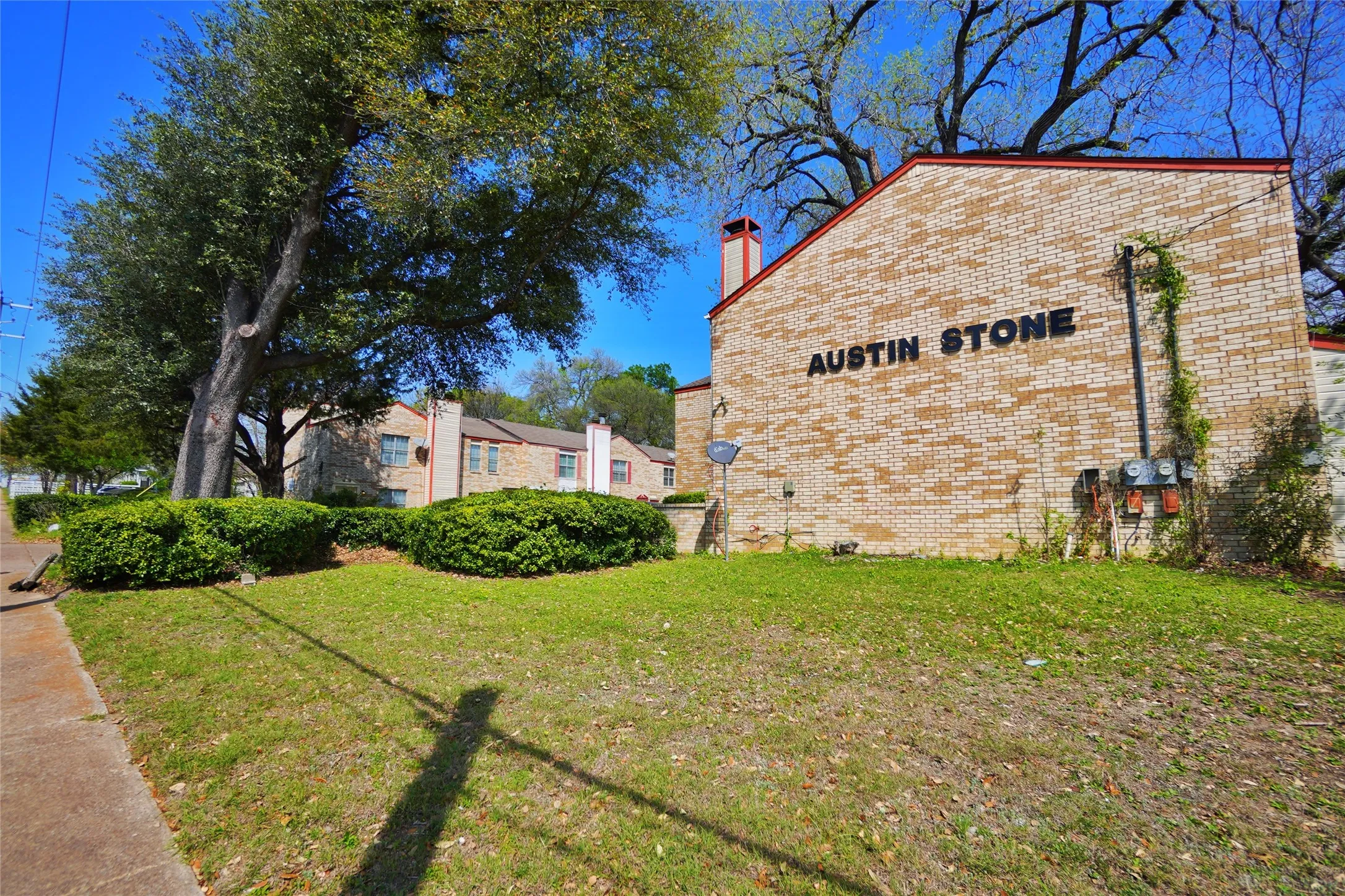 Brick exterior featuring "Austin Stone" lettering and a red-capped chimney
