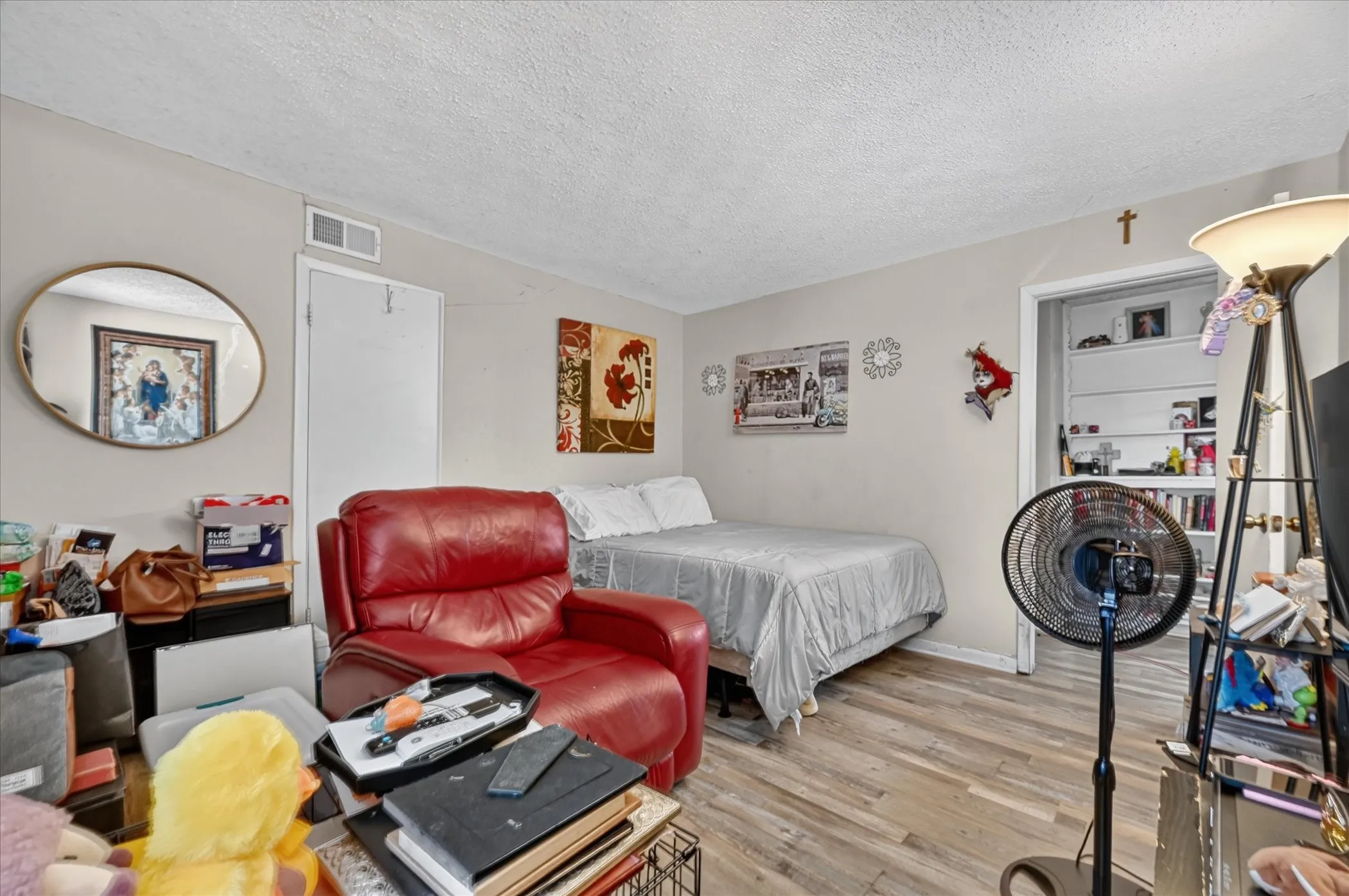 Wood-finish flooring with light-toned walls and a white textured ceiling