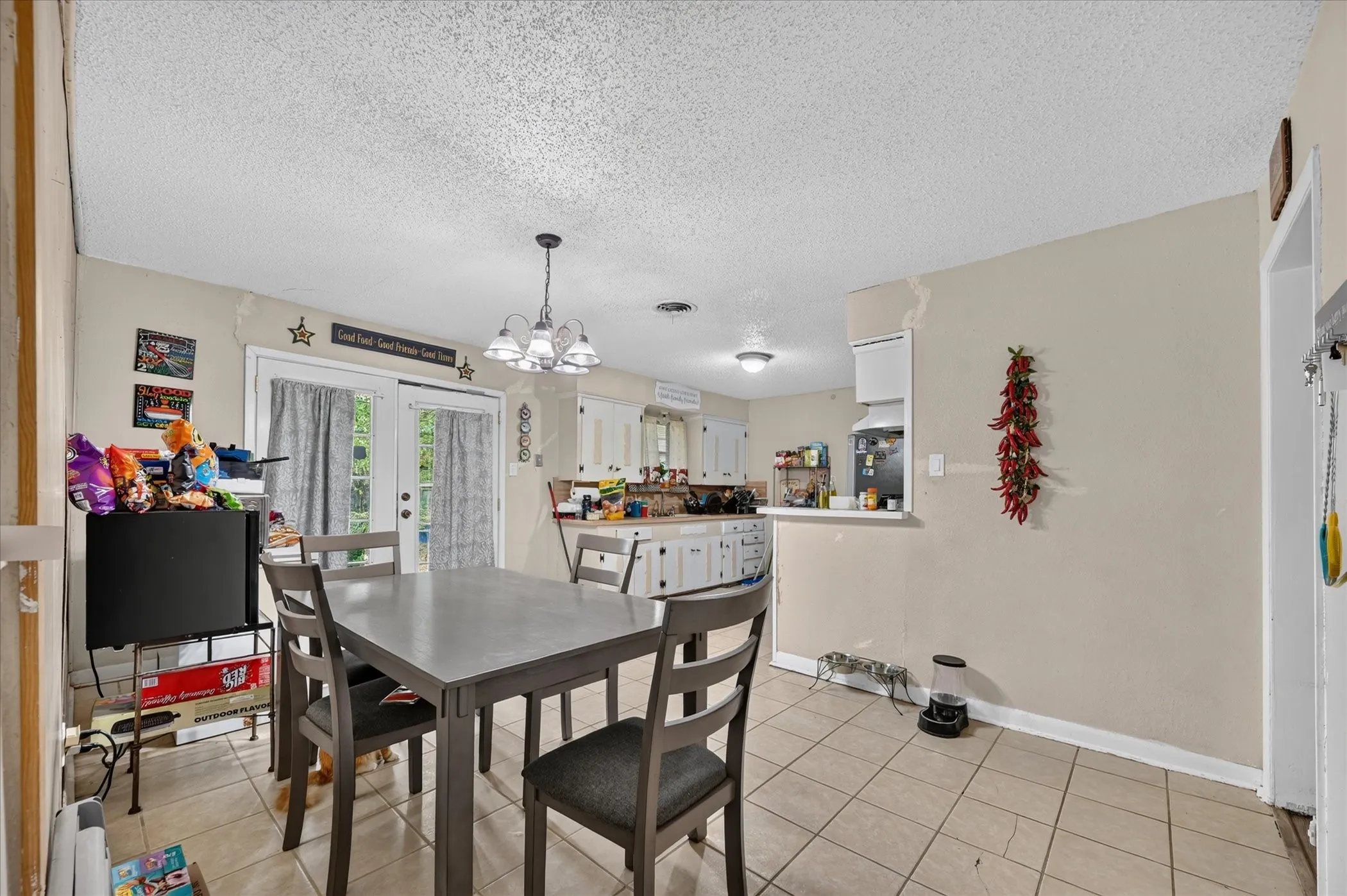 Tiled flooring, white french doors, and a kitchen pass-through window