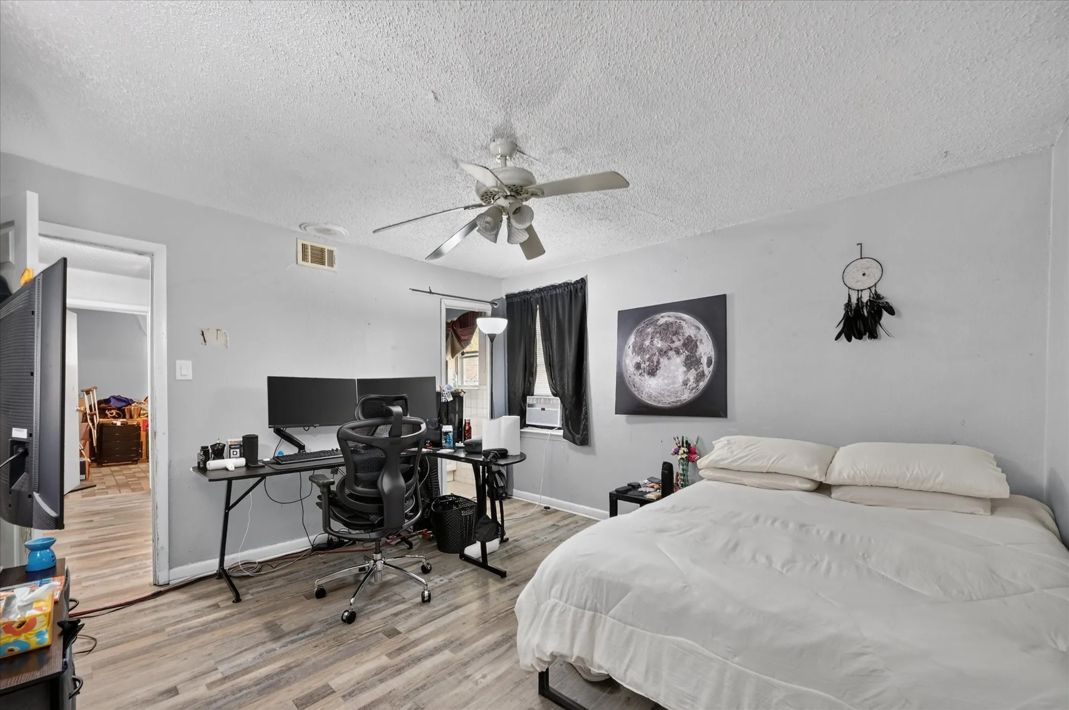 Wood-finish flooring with a neutral wall color and a ceiling fan