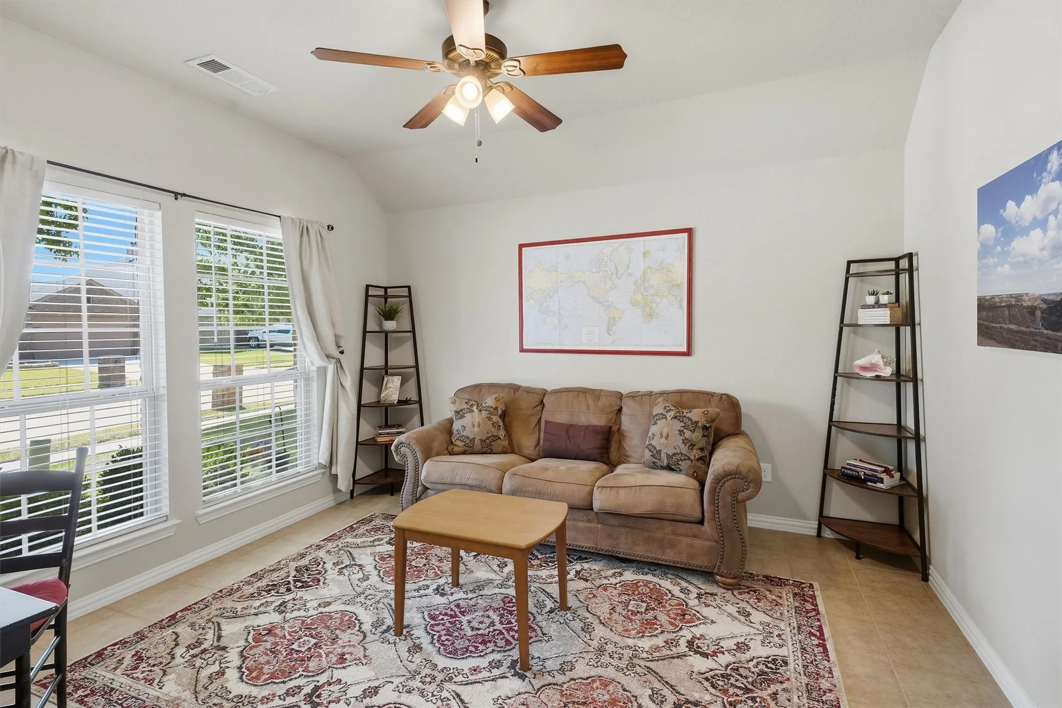 This versatile front flex room features tiled flooring, a soaring vaulted ceiling, and a lighted fan. Large front-facing windows fill the space with bright natural light, making it perfect for a formal dining room, home office, or secondary sitting area.