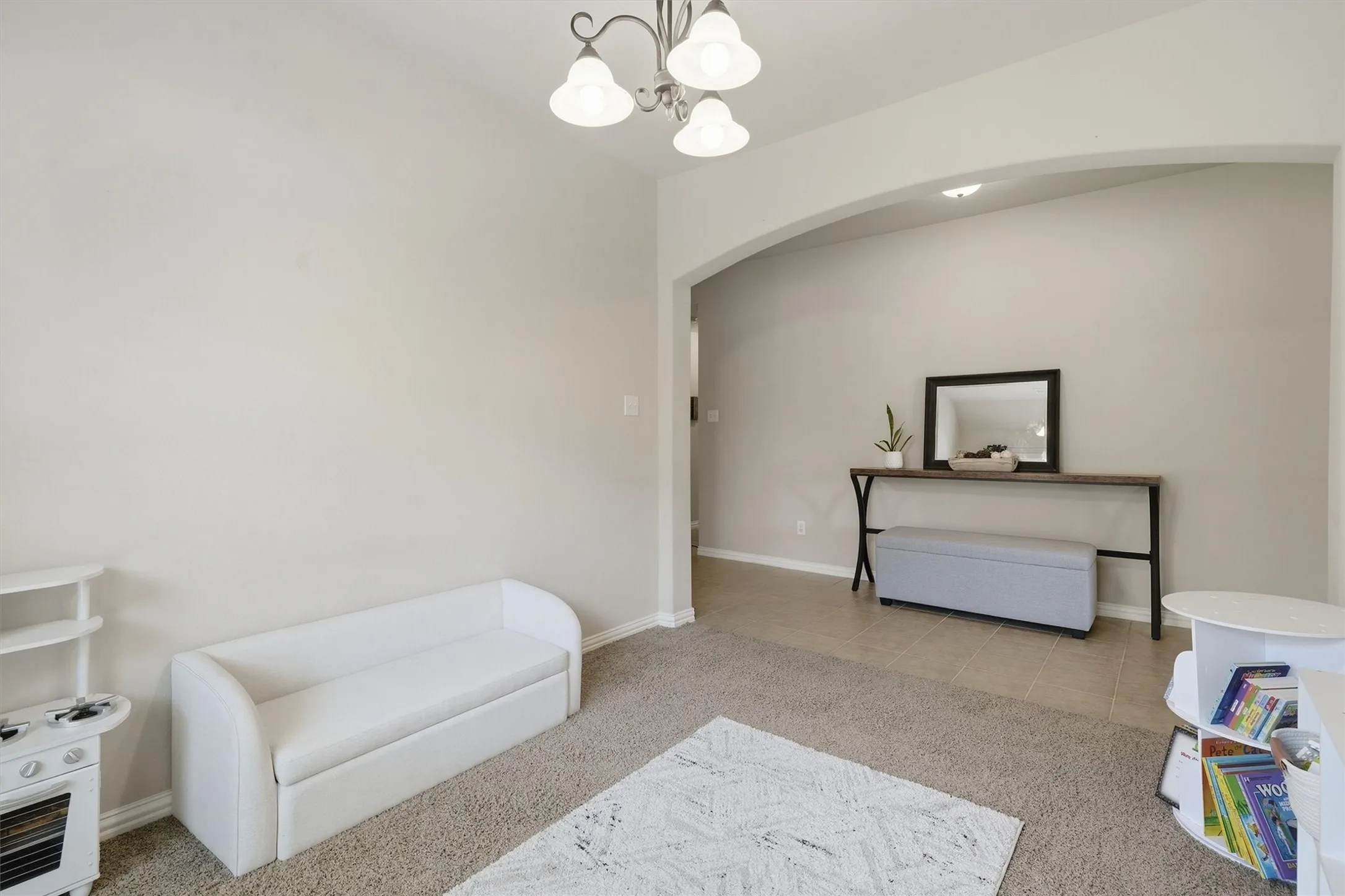 Framed by an arched entryway and highlighted by an elegant light fixture, this adaptable room serves perfectly as a formal dining area, playroom, or dedicated study.