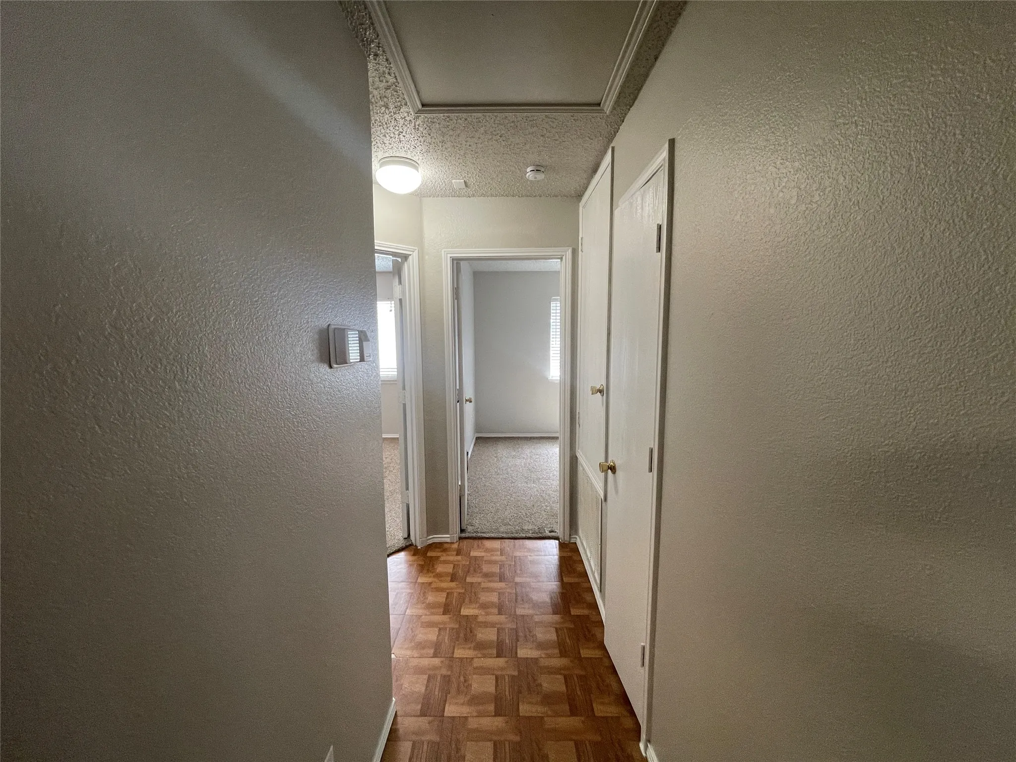Hardwood-finish flooring with a patterned design, neutral wall paint, and recessed ceiling light fixture