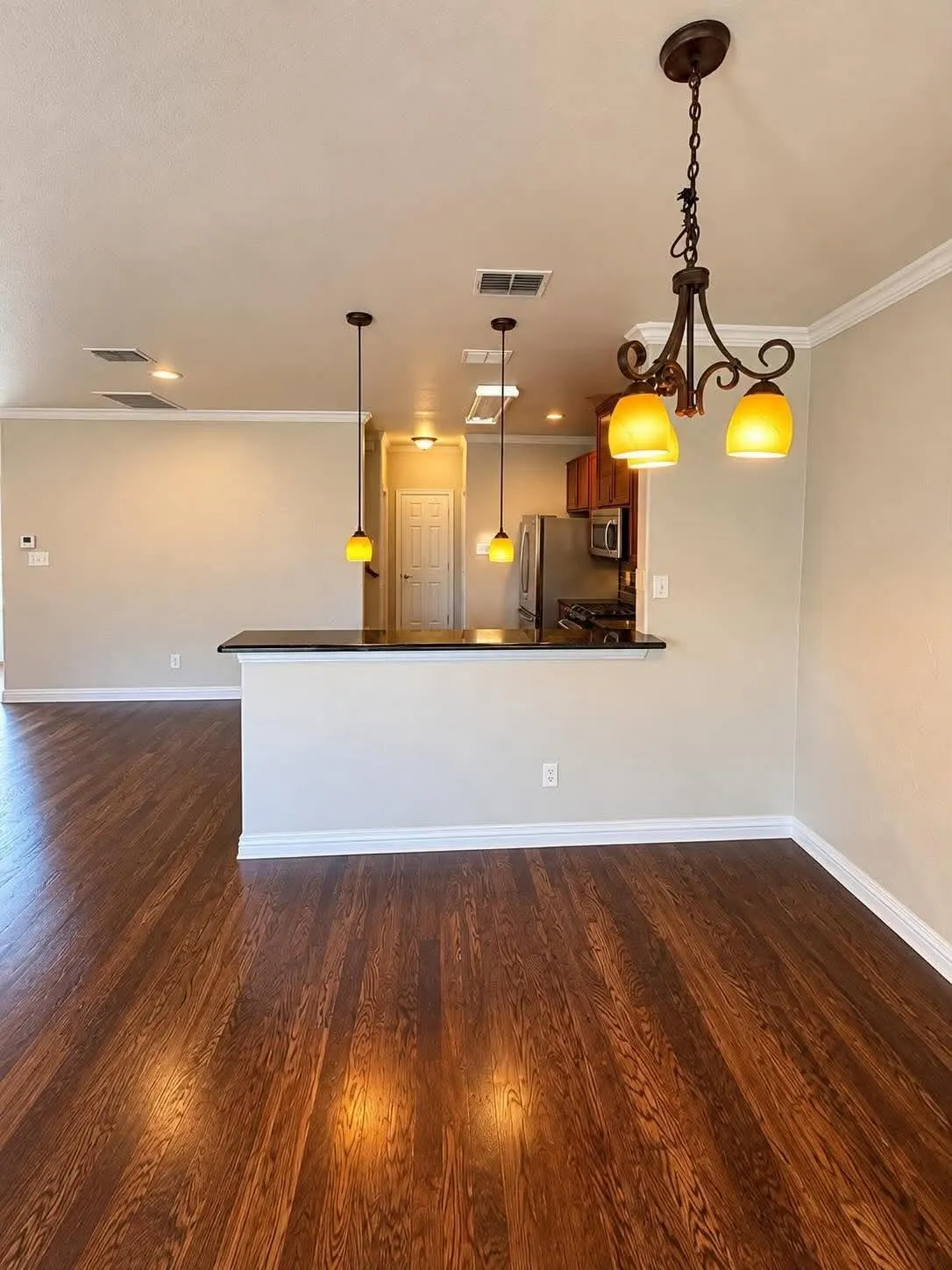 Wood-finish flooring throughout, complemented by crown molding and recessed lighting