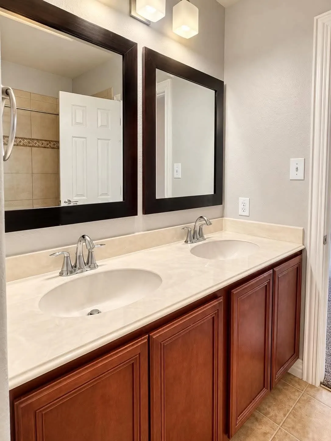 Double vanity featuring a light-toned countertop with integrated sinks and chrome faucets