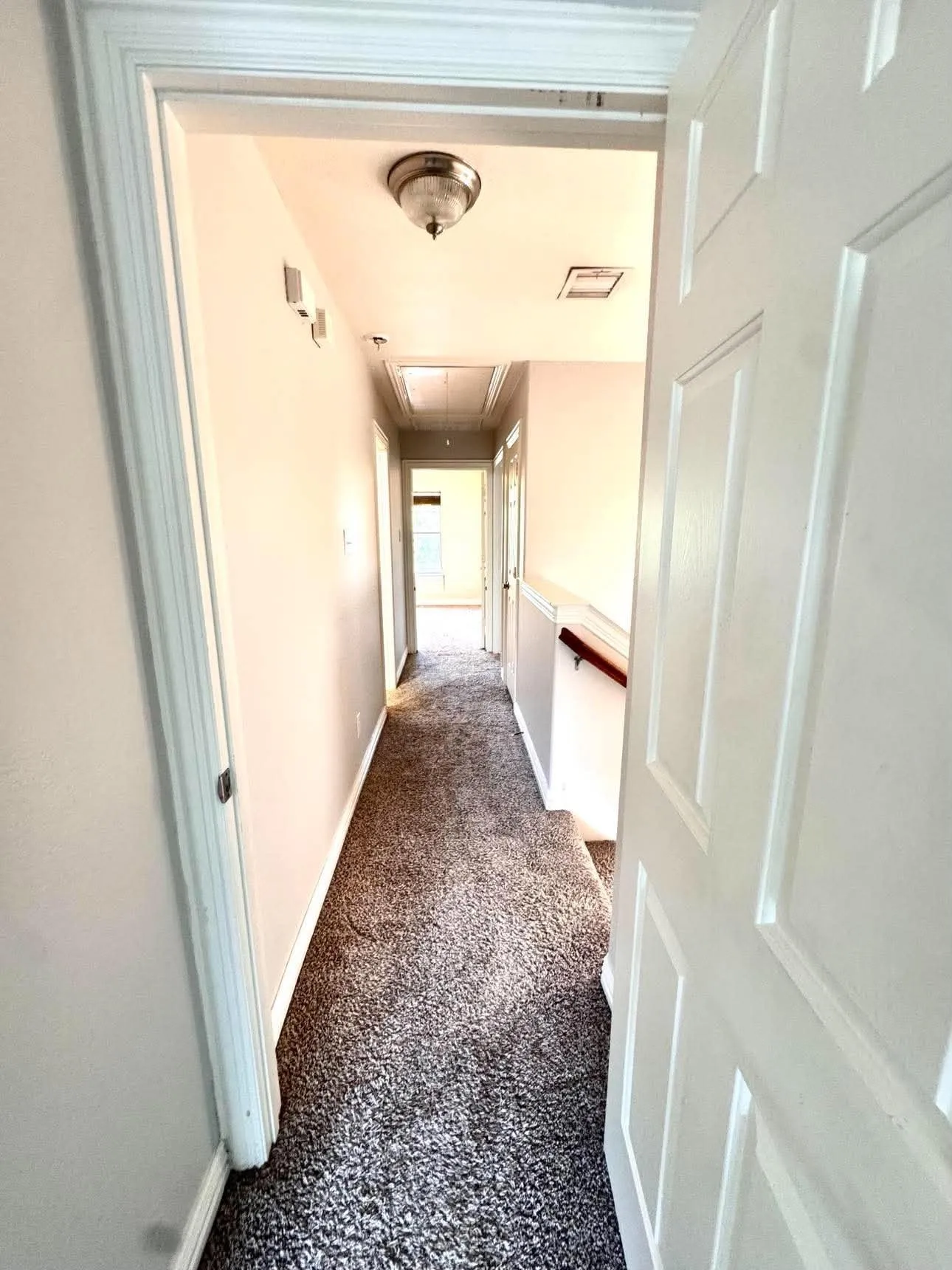 Hallway featuring carpet flooring, painted walls, and a flush mount light fixture