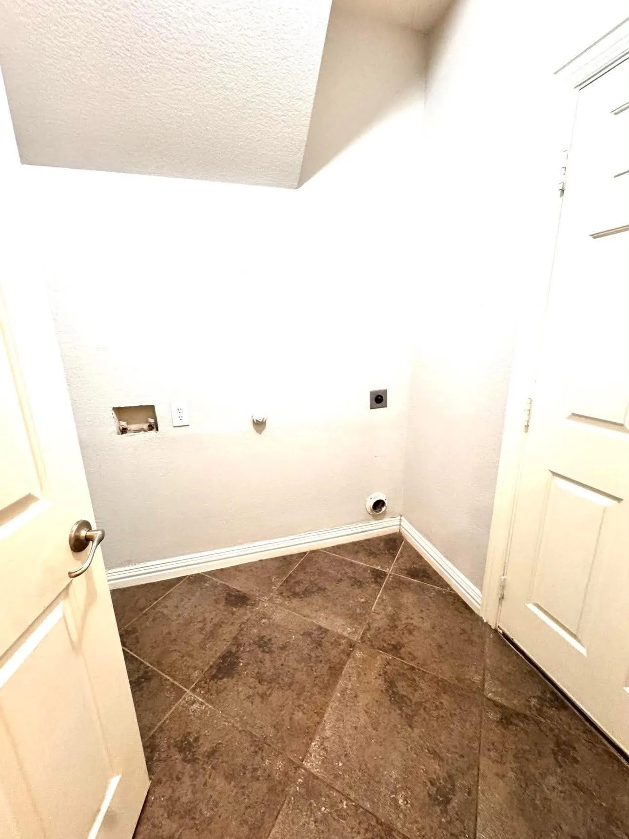 Tile flooring, white walls, and a textured ceiling