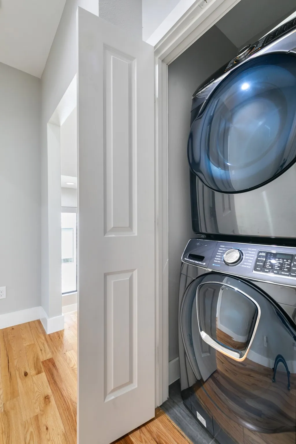 Dedicated laundry closet featuring a stacked washer and dryer