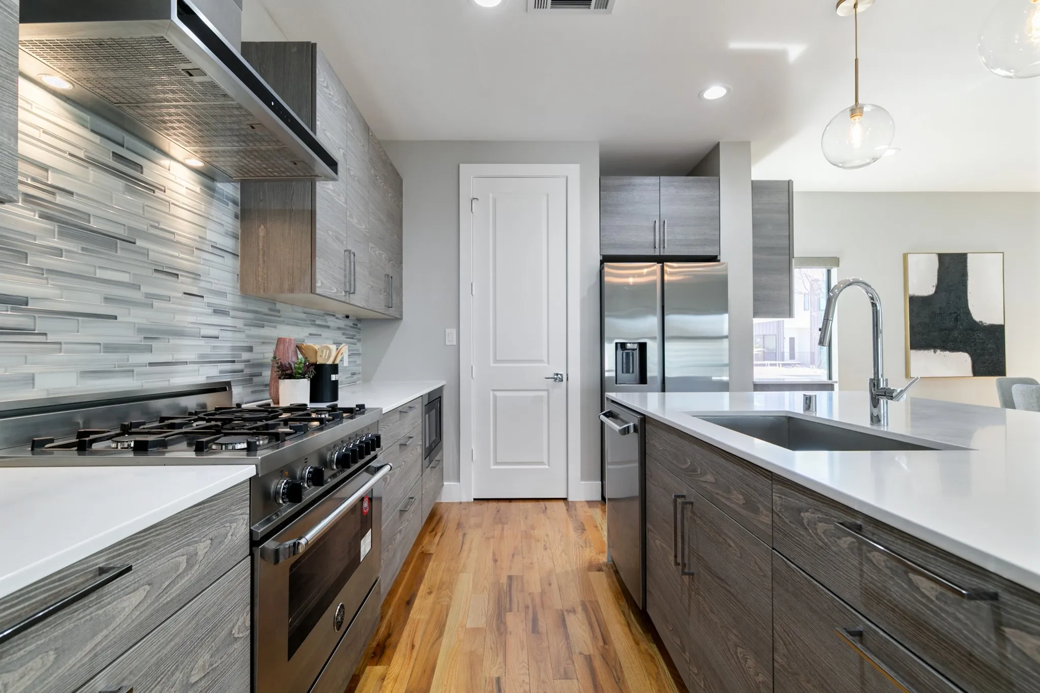 Modern kitchen featuring wood-finish cabinetry, stainless steel appliances, and light-toned countertops