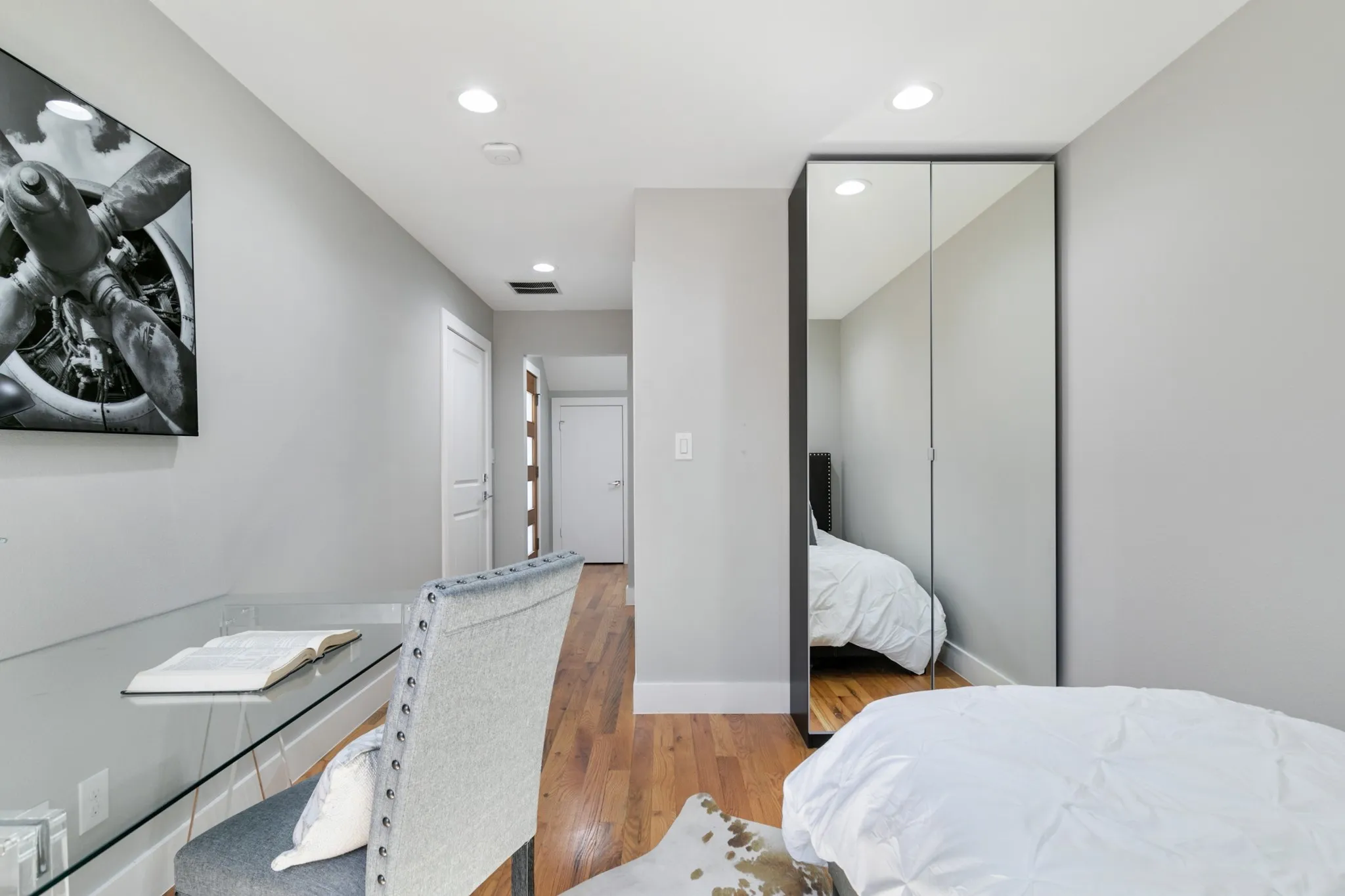 Recessed lighting, wood-finish flooring, and a mirrored wardrobe
