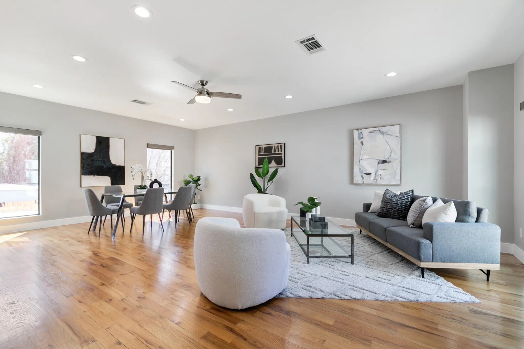Open-concept living area featuring wood-finish flooring, recessed lighting, and expansive windows