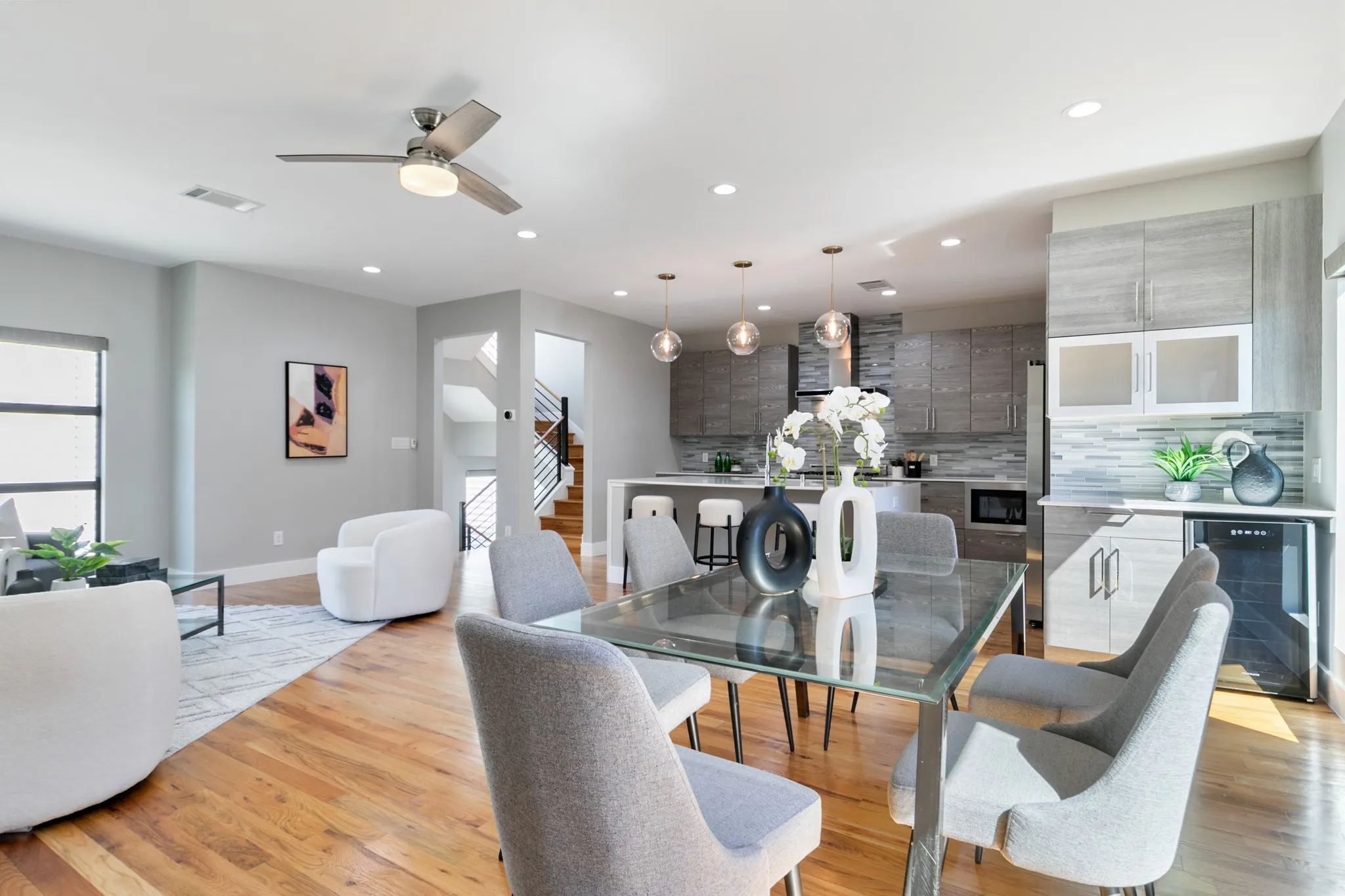 Open-concept living space featuring wood-finish flooring, recessed lighting, and a contemporary ceiling fan