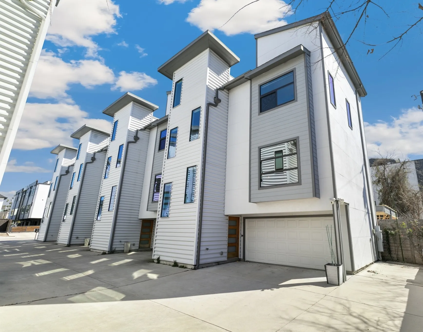 Contemporary architectural design with multi-level facades, white siding, and varied window placements