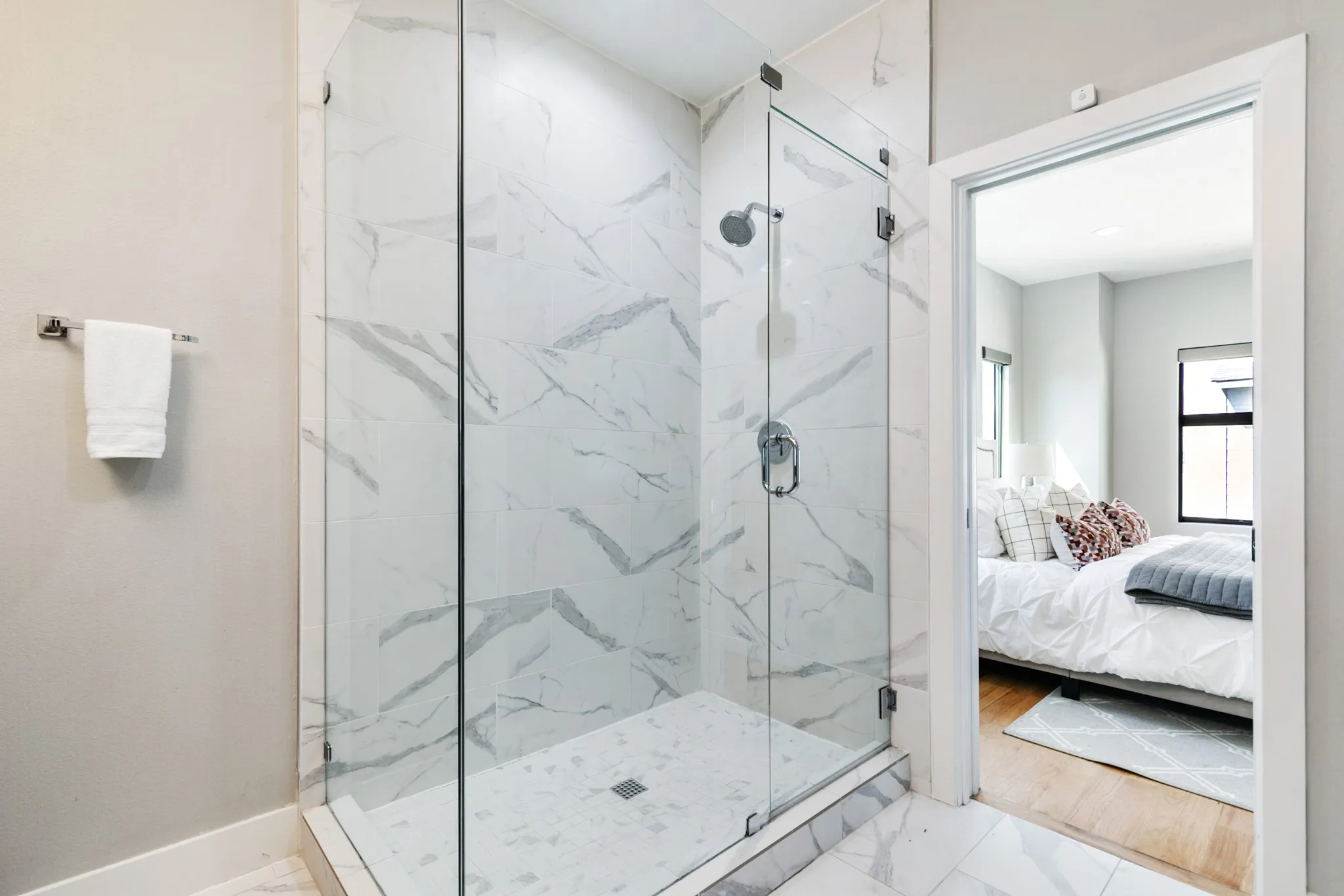 Shower with glass enclosure, large format wall tile, rain shower head, and wall-mounted shower control
