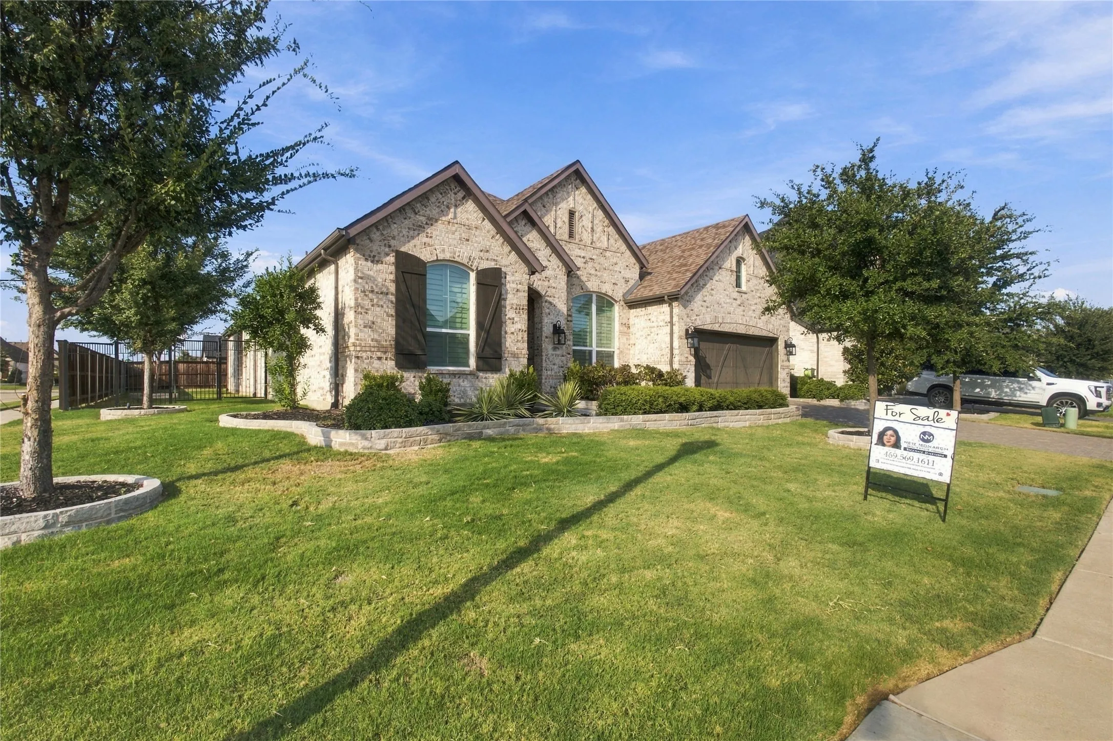 Brick facade residence with a gabled roofline, front-facing garage, and decorative window shutters