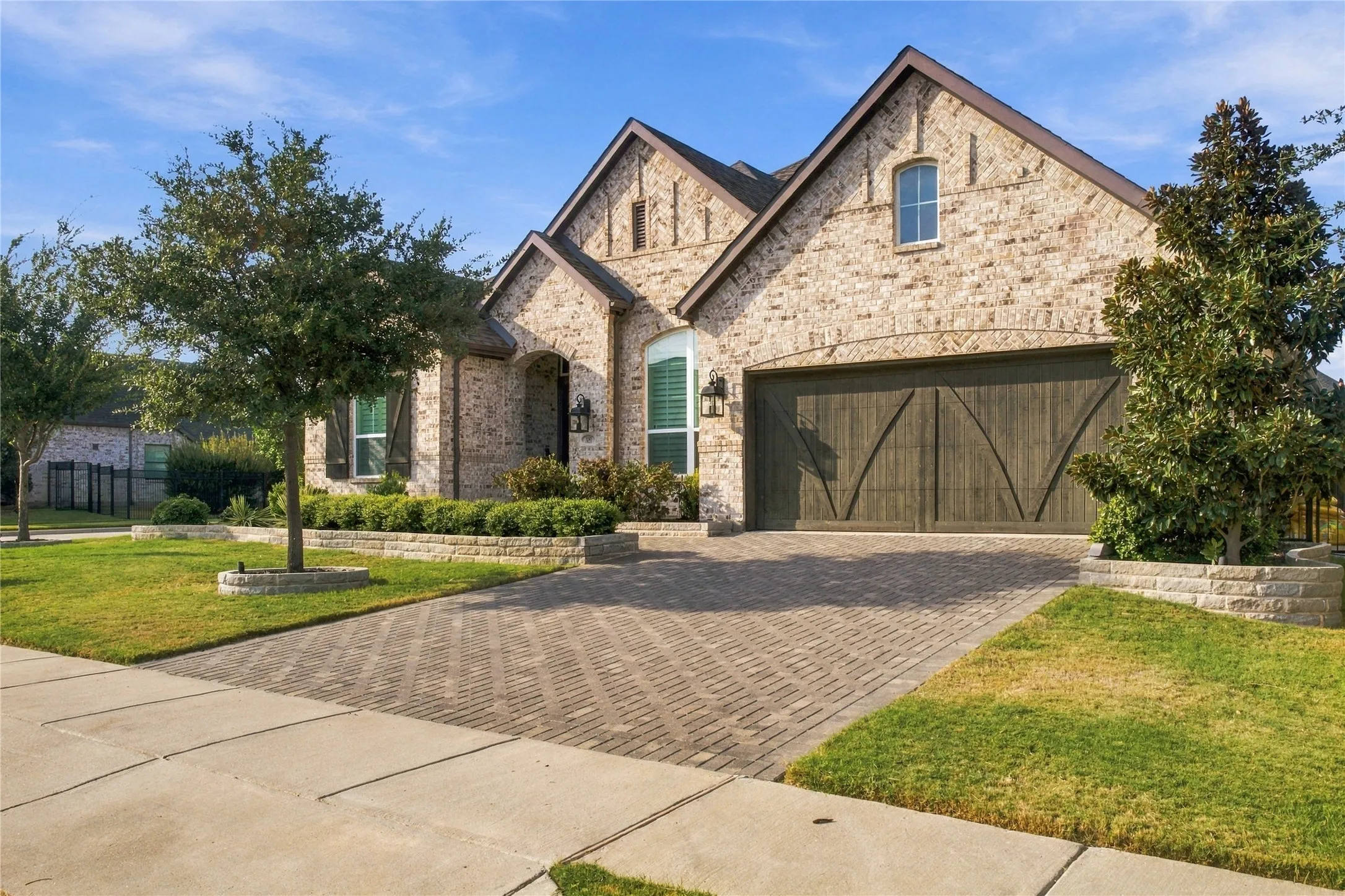 Brick exterior, arched entry, paver driveway