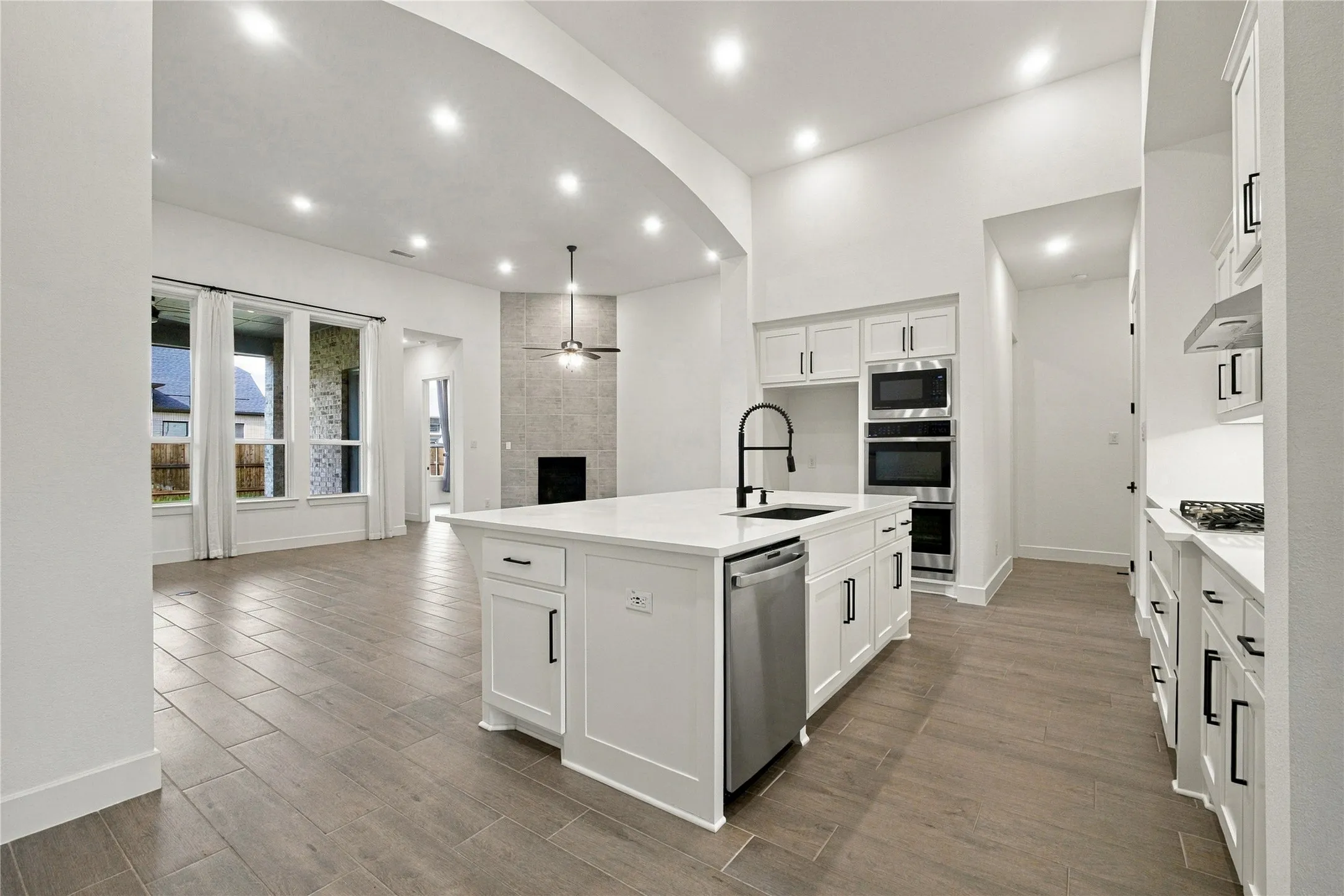 Kitchen island with integrated sink, stainless steel dishwasher, and built-in microwave and oven