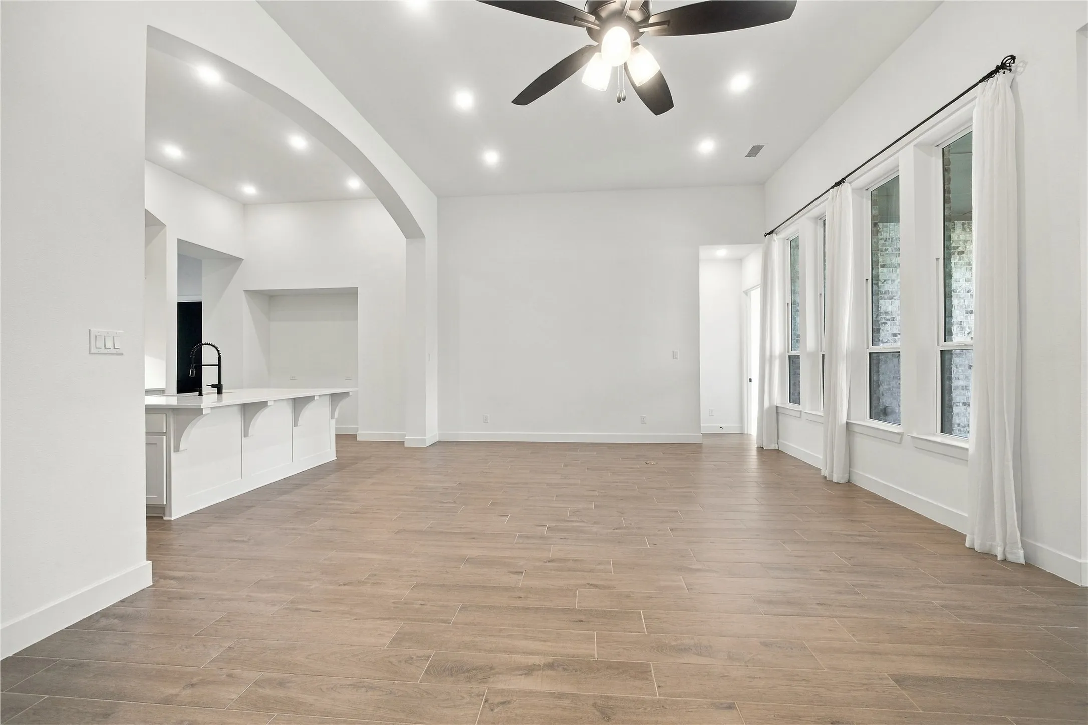 Wood-finish flooring, recessed lighting, and a ceiling fan