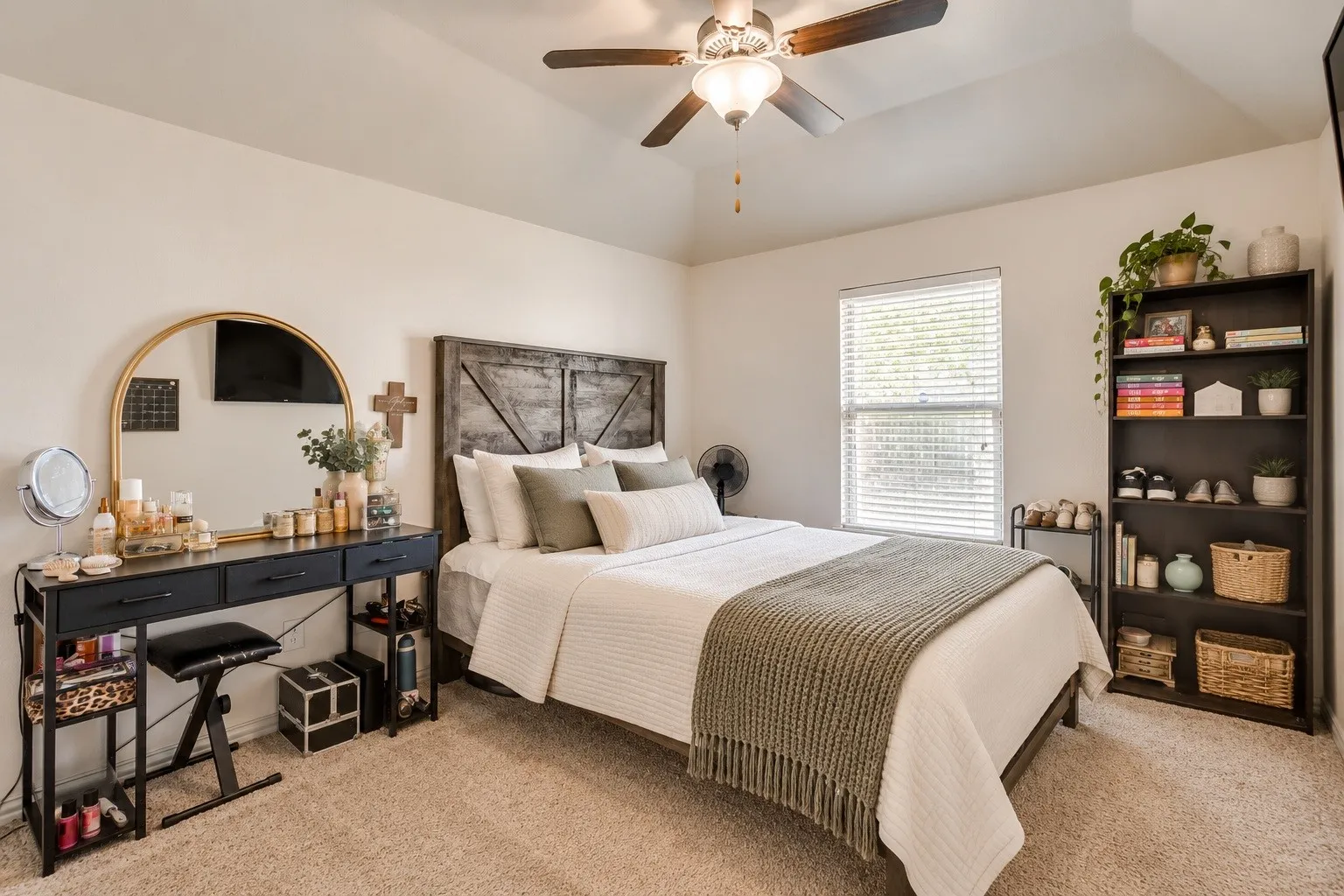 Neutral wall paint, plush carpeting, ceiling fan with integrated lighting, window with blinds, and built-in shelving. Picture virtually edited