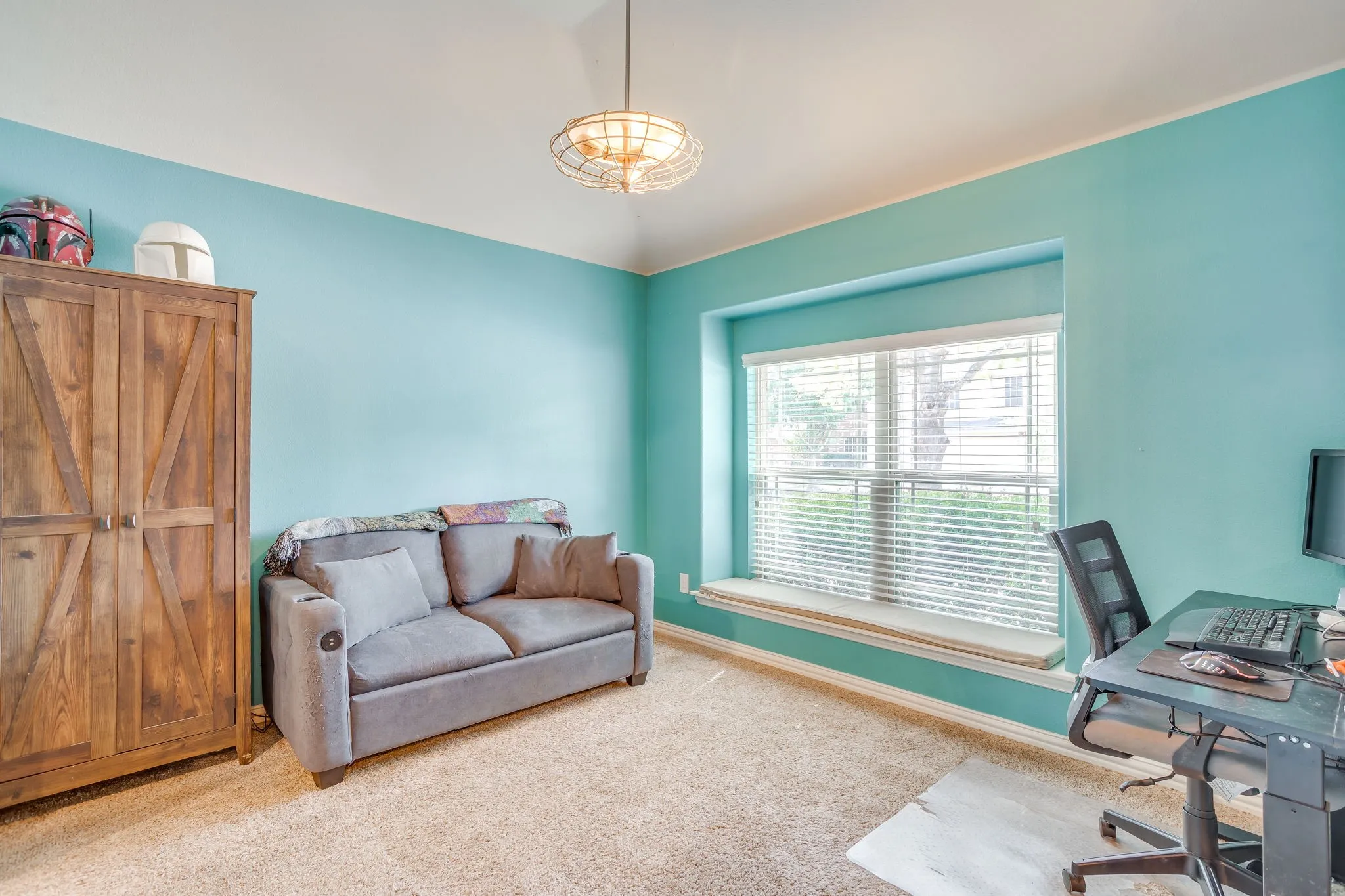 Vaulted ceiling with a contemporary flush-mount fixture, large window with a built-in window seat, and carpet flooring