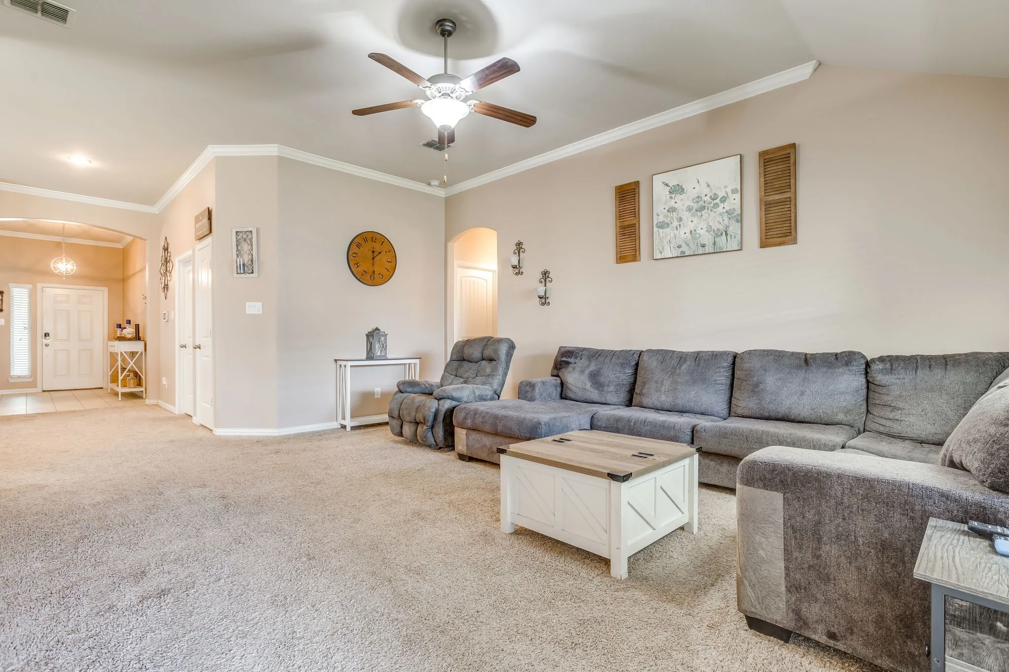 Neutral-toned carpeted flooring with a ceiling fan light fixture