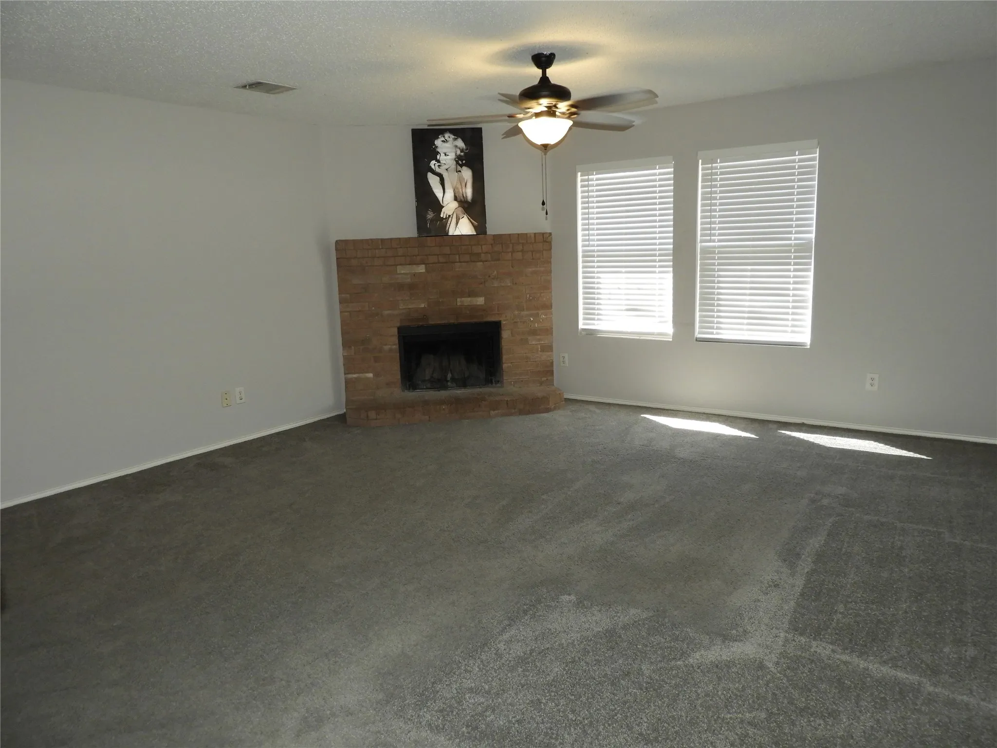 Oversized living room with corner fireplace and ceiling fan.